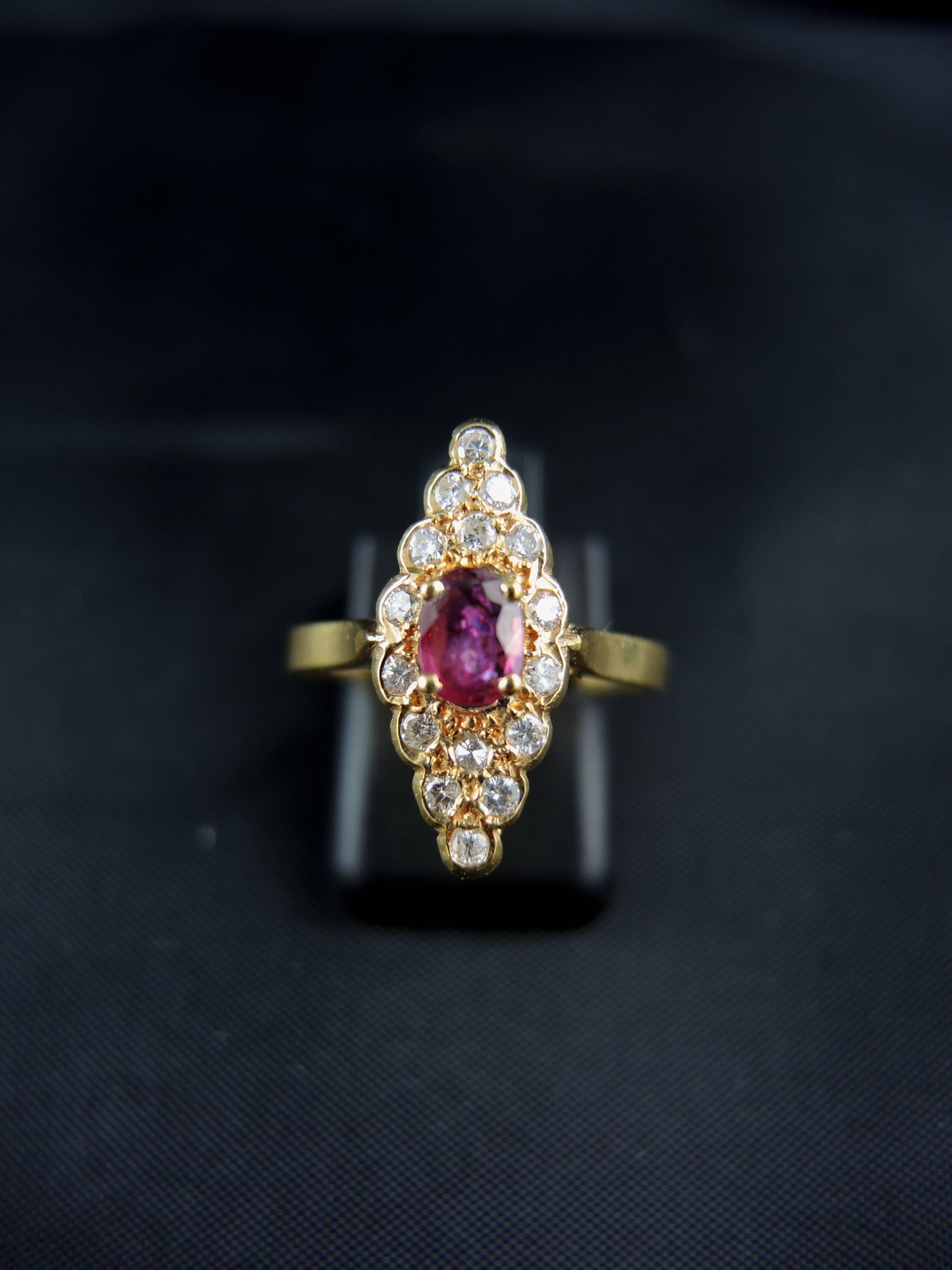 Yellow gold navette ring (quality mark: eagle's head) with a central ruby, weight estimated  around 0,20 Ct, surrounded with modern brillant cut diamonds, which total weight is estimated around 0,25 Ct.

 French work, circa 1980.

Weight: 2,60g
Ring