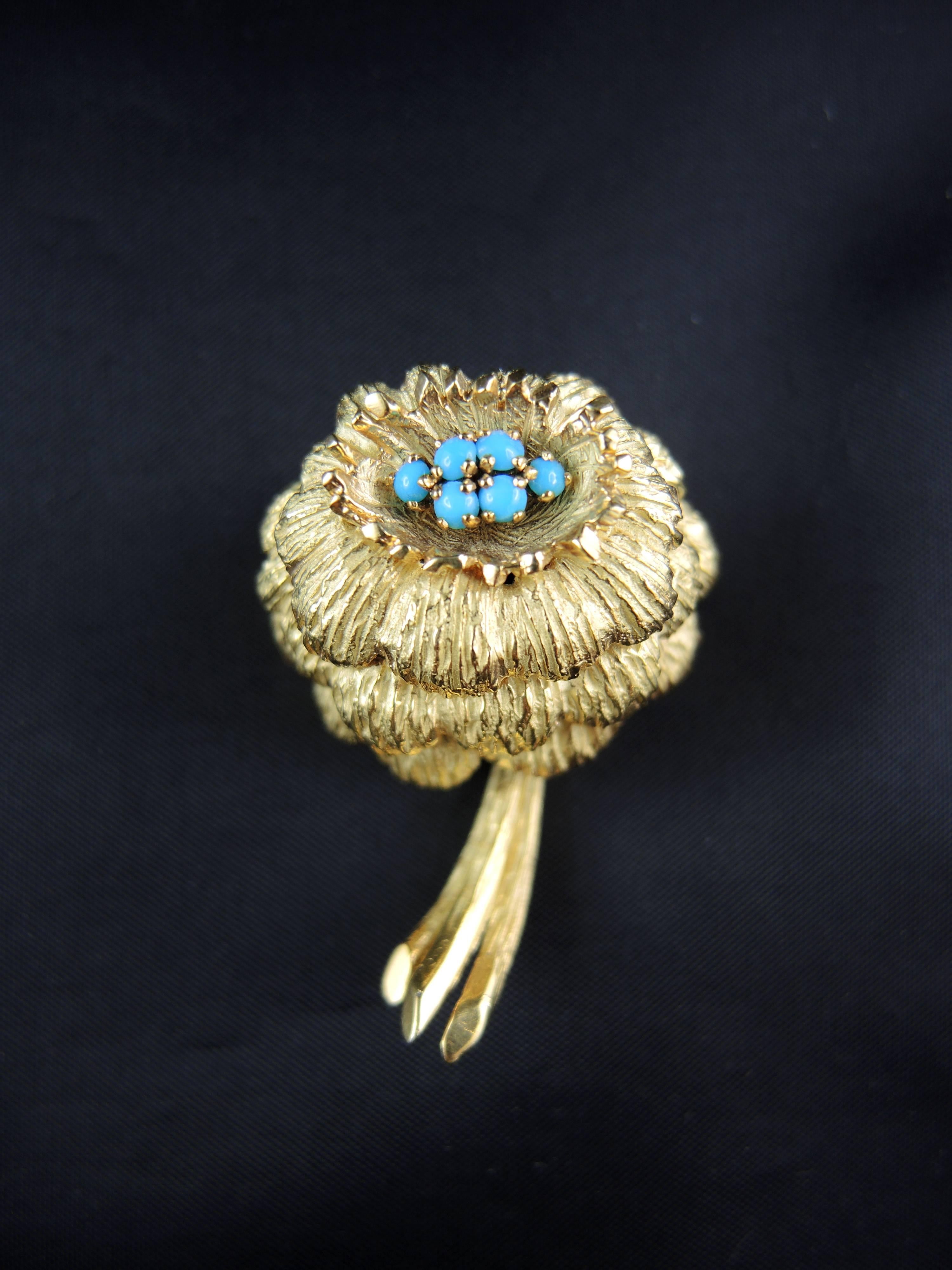 Glamourous Flower brooch made in 18 KT yellow gold (quality mark: eagle's head), set with turquoise's cabochon.

French work circa 1970, by Michèle Morgan, a famous french actress.

Height: 4.00 cm

Very little scratches on the gold parts, visible