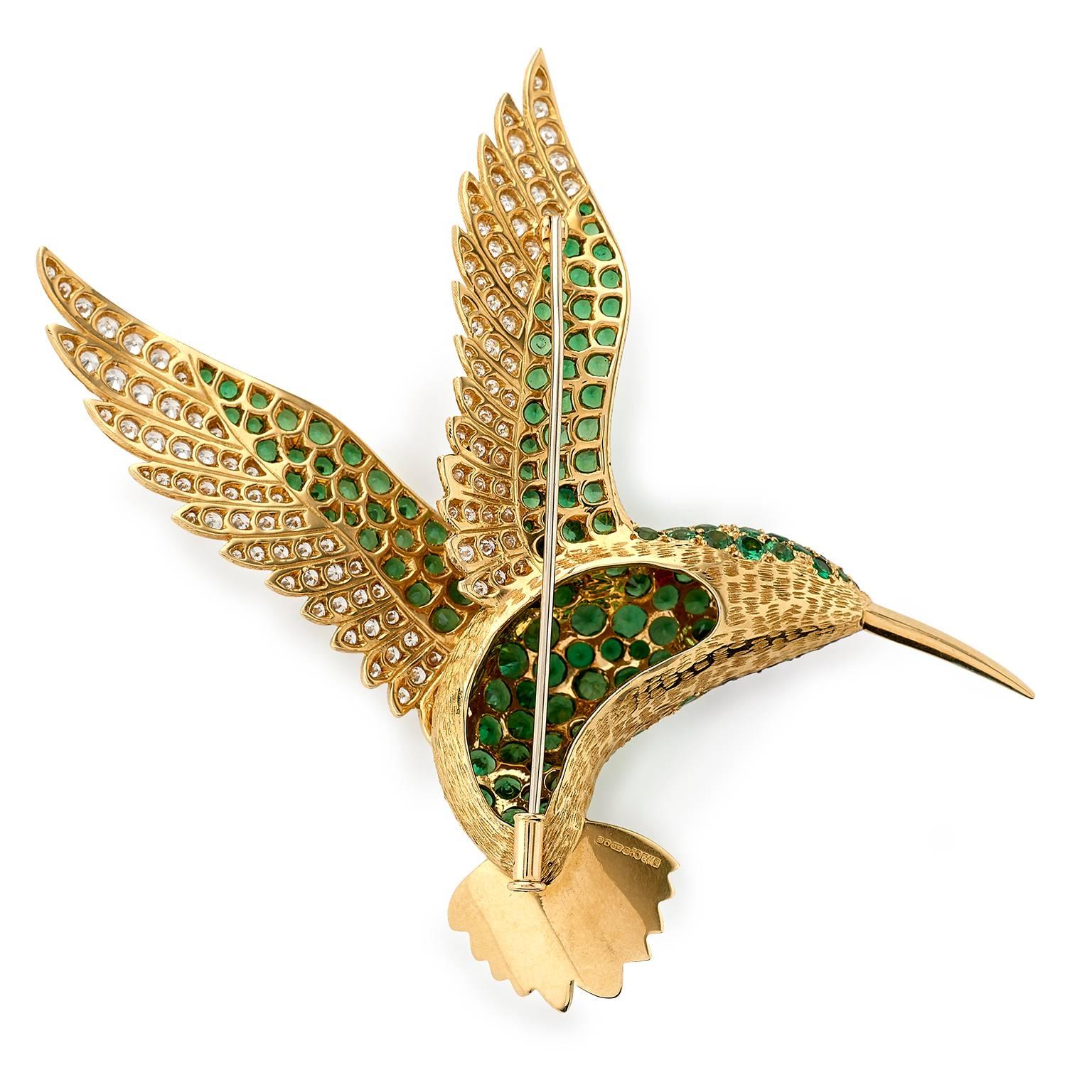 Hummingbird brooch made in 18 carat yellow gold and set with 2.10 carats white diamonds to wing, 10.50 carats tsavorite garnets to his body, .80 carats rubies and black onyx eye. With easy to use yet secure tube catch fitting to the back of the