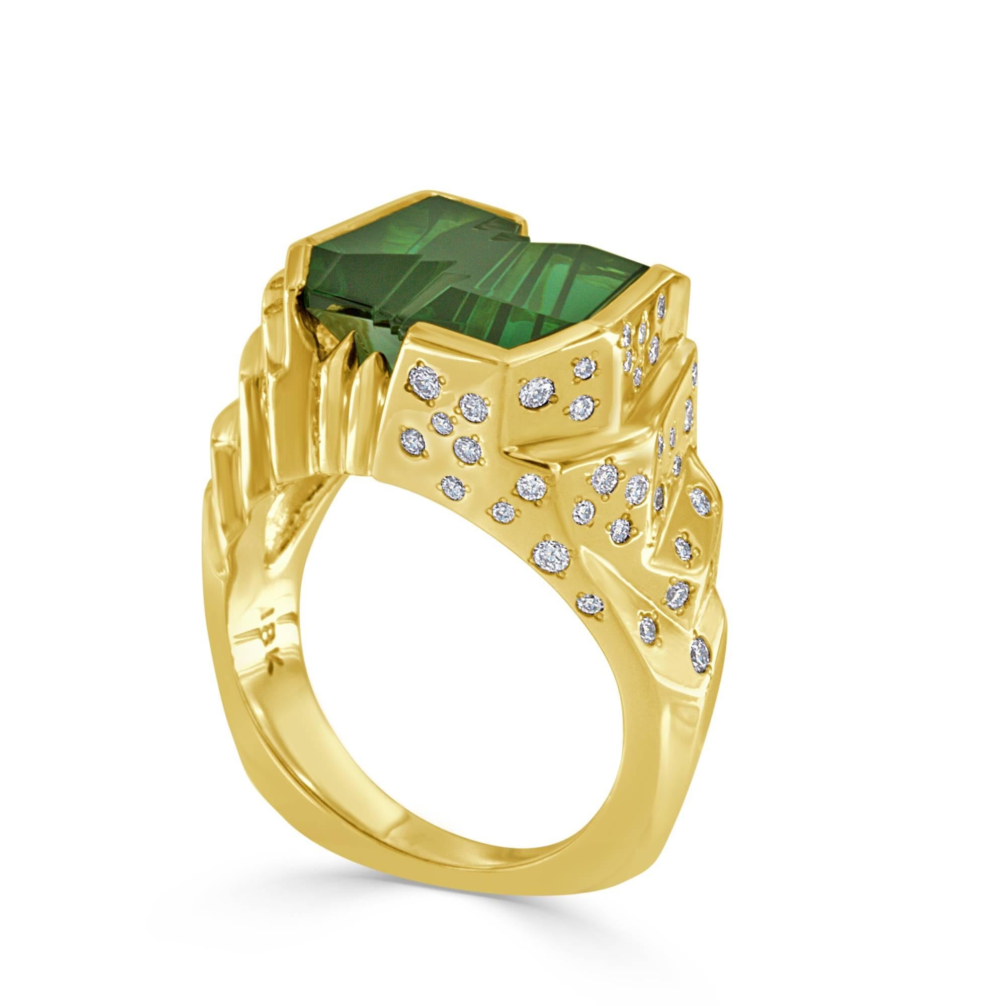 This ring is truly one-of-a-kind and rare piece, featuring a fantasy cut green tourmaline crafted by world renowned gem artist Bernd Munsteiner, this 6.93ct tourmaline has captivating green color. The equally unique 18 karat yellow gold ring