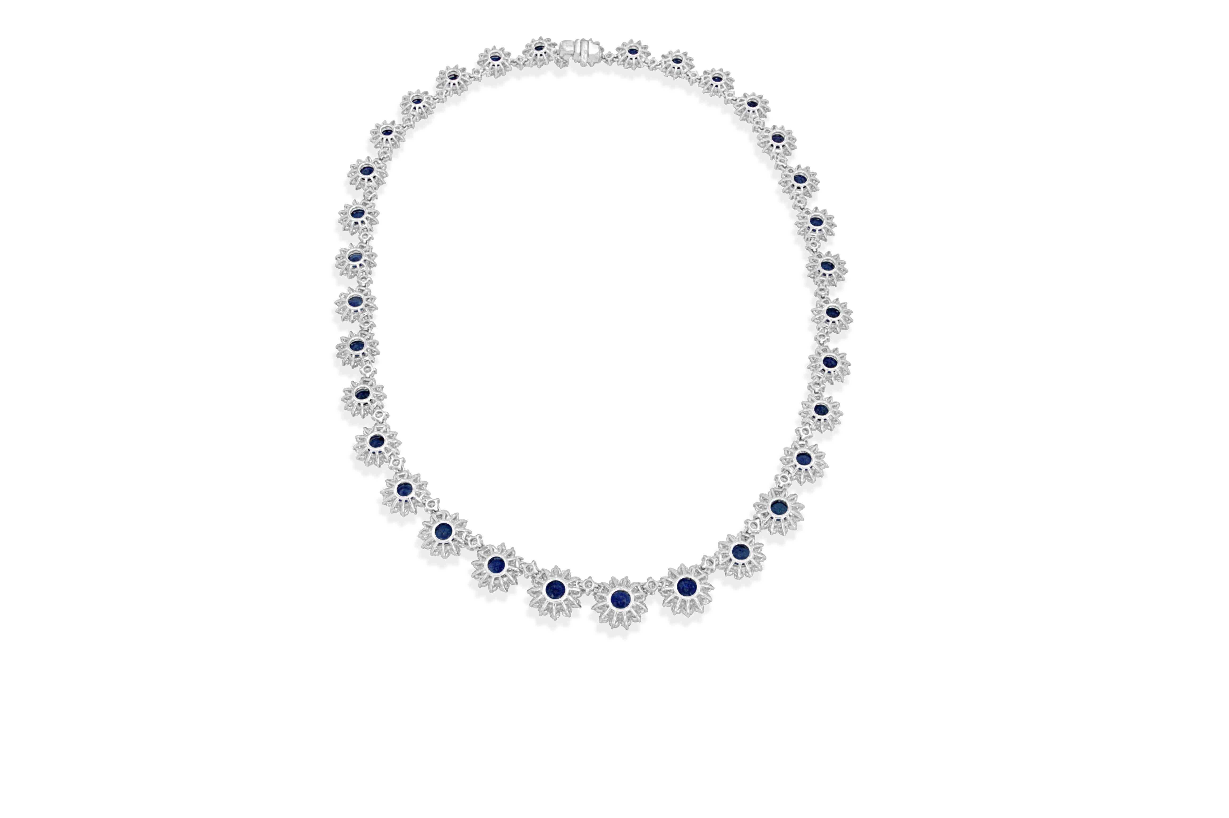 This elegant 18 karat white gold necklace features 33-round cut sapphires, total carat weight of 26.54cts, having exceptional cut and color. Each sapphire adorned with a diamond halo.  The 429-round brilliant cut diamonds have a total carat weight