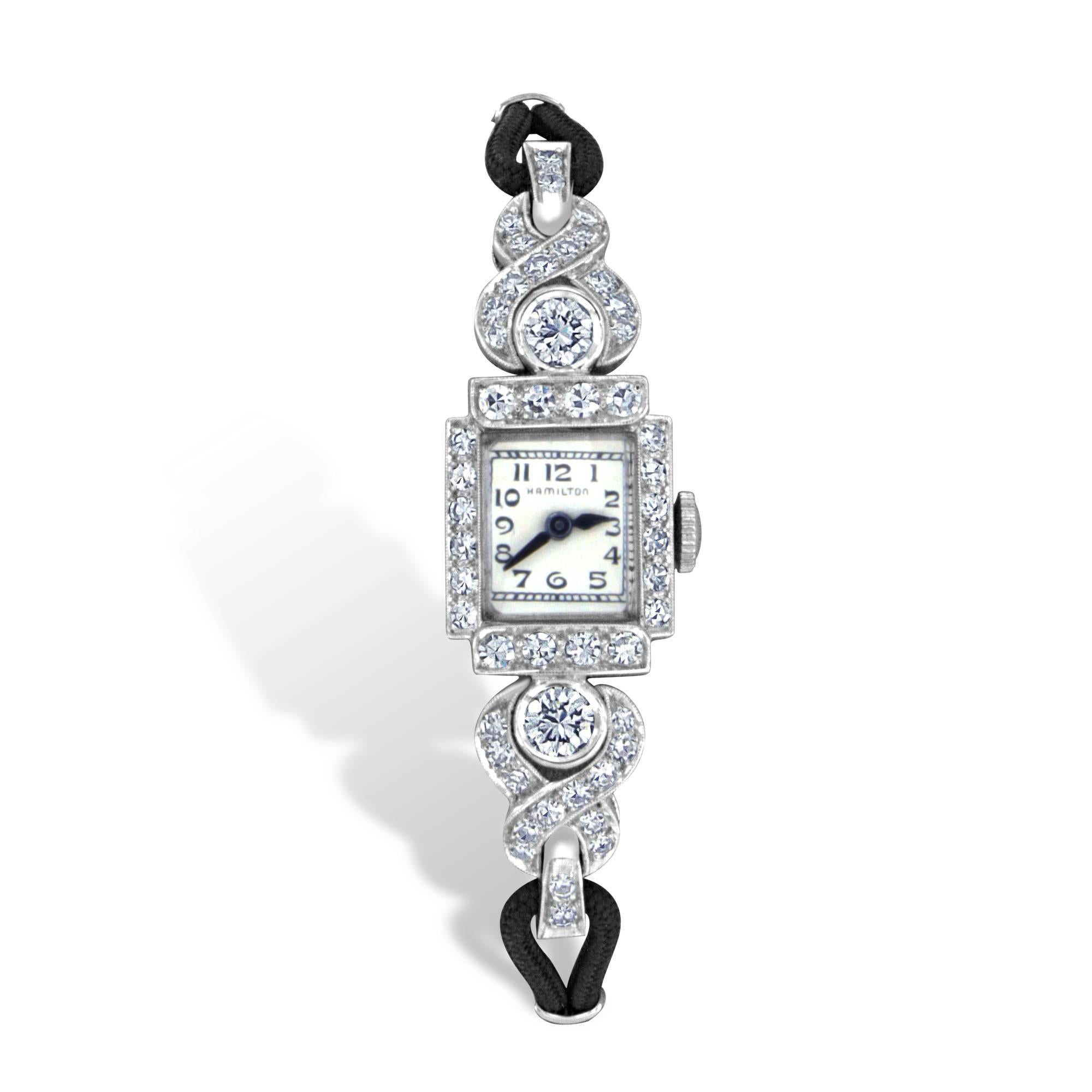 This dignified Hamilton diamond wristwatch from the mid 1900’s features 2-Old European cut diamonds having VS2 clarity and G color, and 34-single cut diamonds weighing 2.32 carats total, having VS2 to SI1 clarity and F color.  This platinum watch
