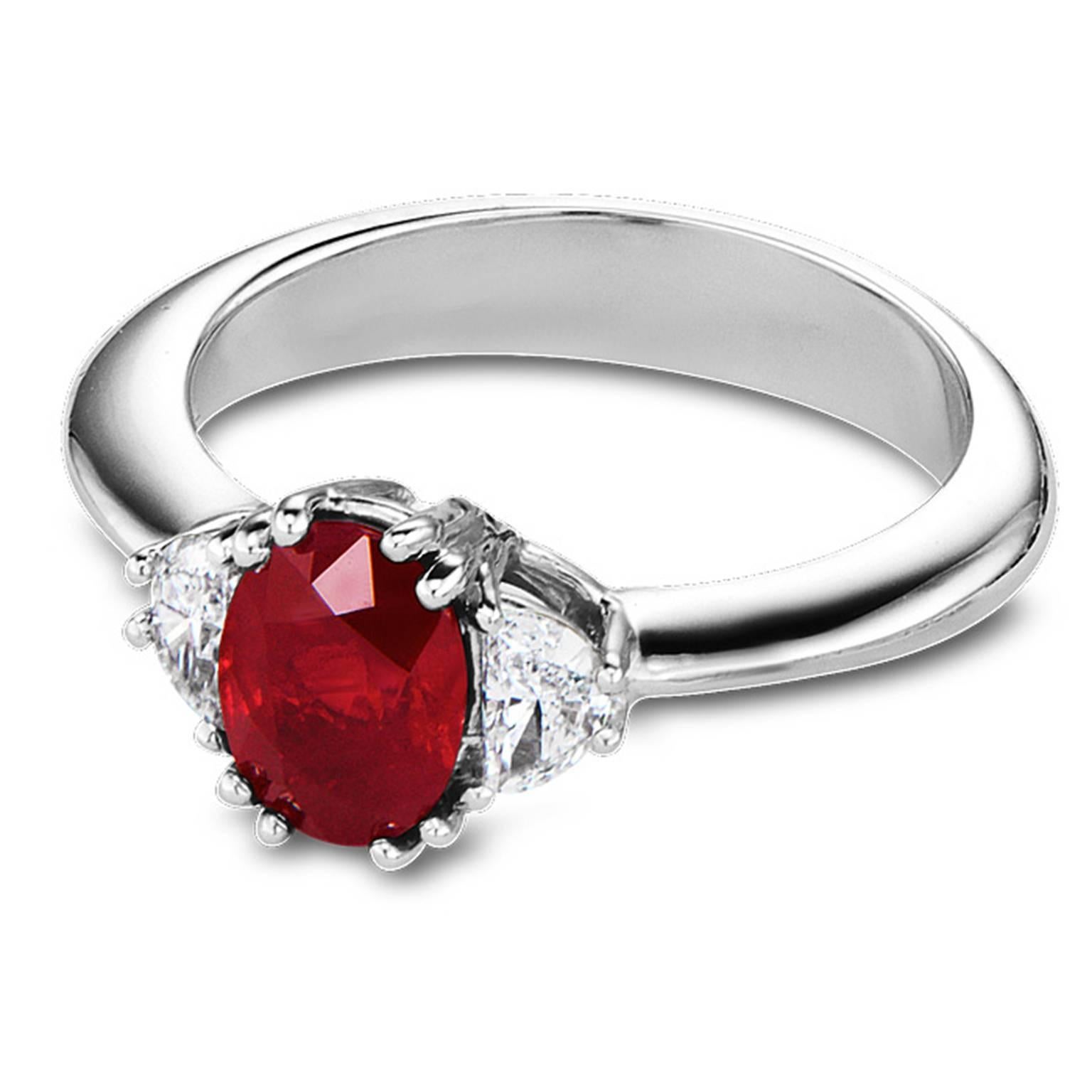 This exquisite ruby and diamond ring features an oval cut ruby weighing 1.15 carats having excellent color and cut, set between two half moon cut diamonds weighing 0.43 carats total, having VS2 clarity and G color. This timeless platinum ring is a