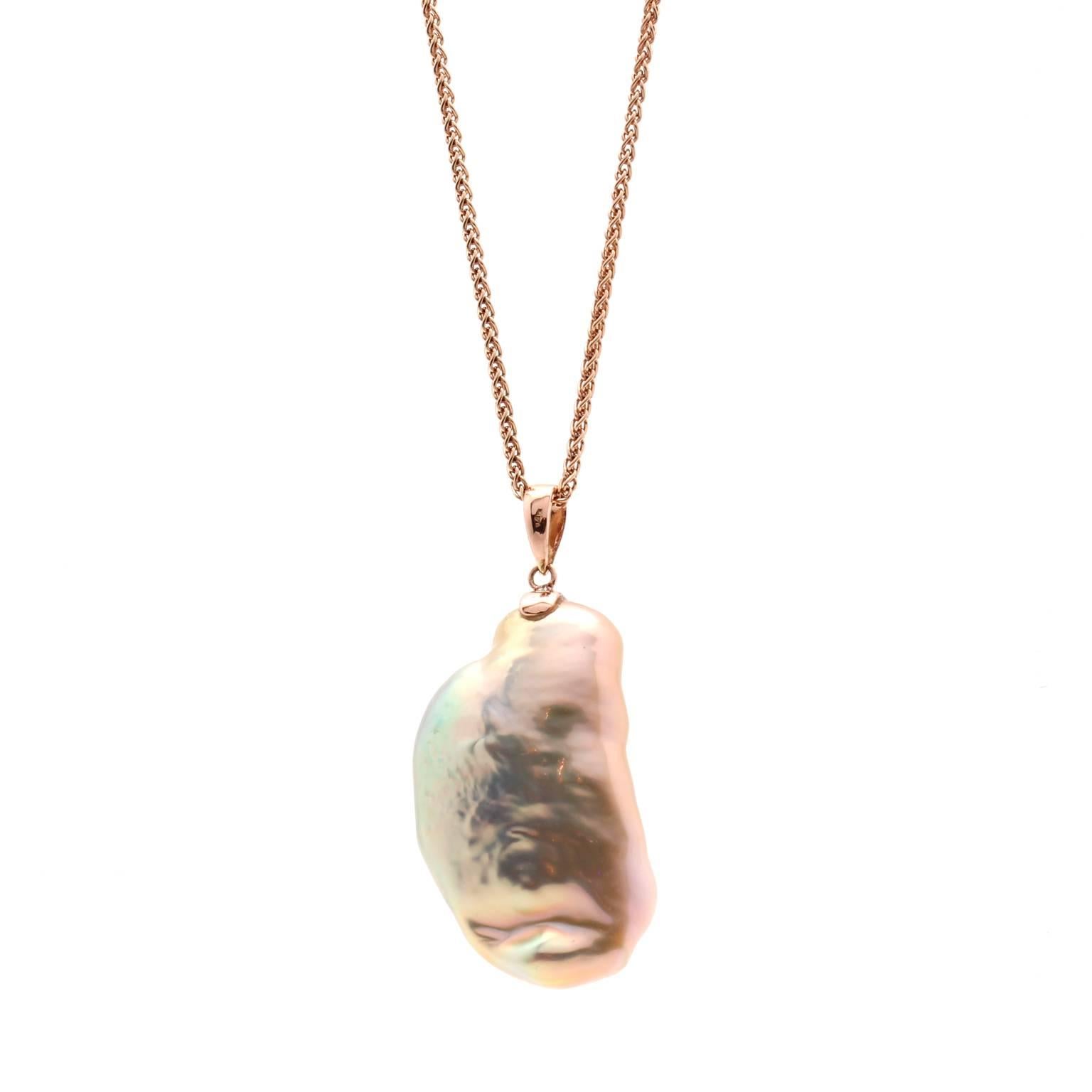 This one-of-a-kind pendant features a 14k rose gold coiled snake with white diamond accents. The snake contours around a freshwater "souffle" pearl. The pearl has an incredible luster and rainbow of colors. 

The pearl measures 38mm in