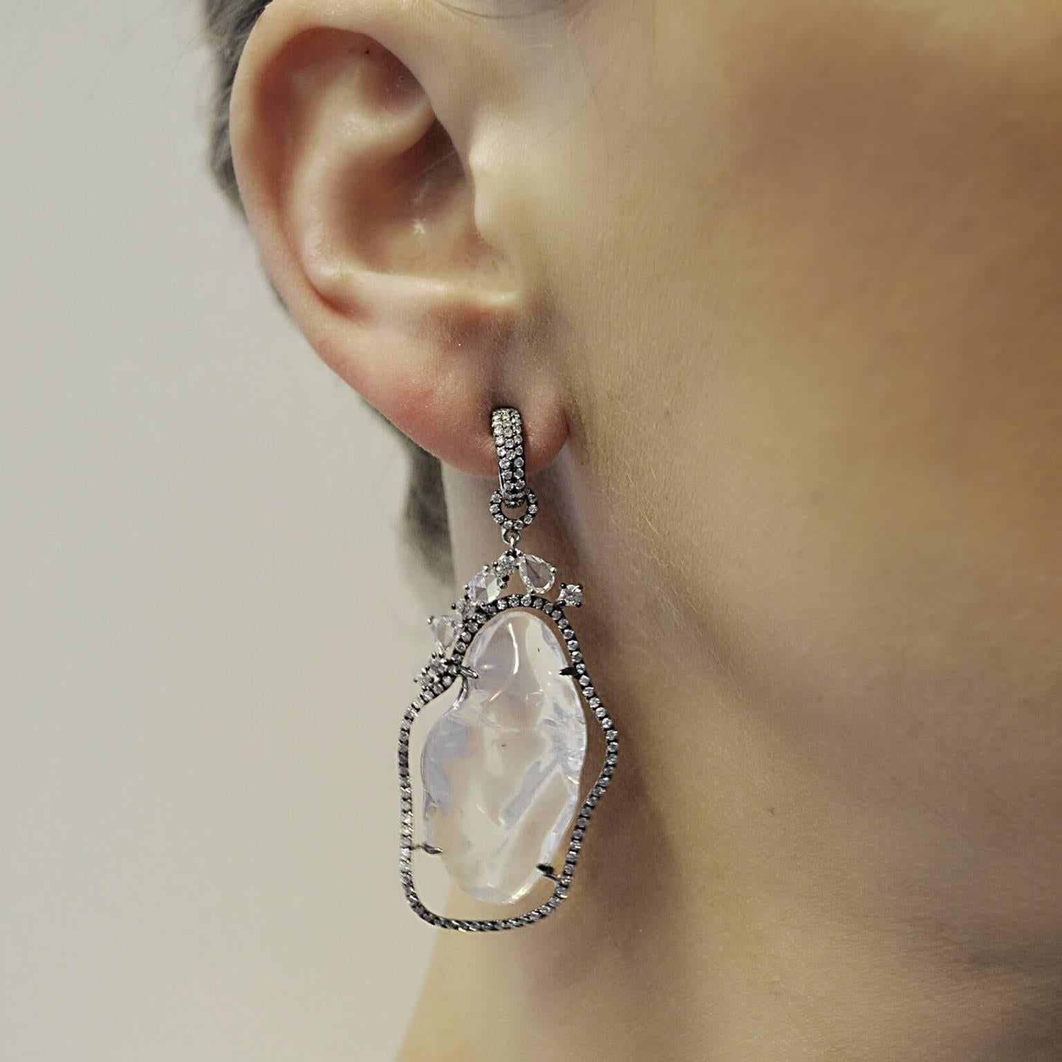 This unique 18k Black Rhodium Earring contains two White Opals at approximately 27cts each.  They are both surrounded by a frame of white pave diamonds containing approximately 2.37 total carat weight with fancy cut diamonds towards the top at