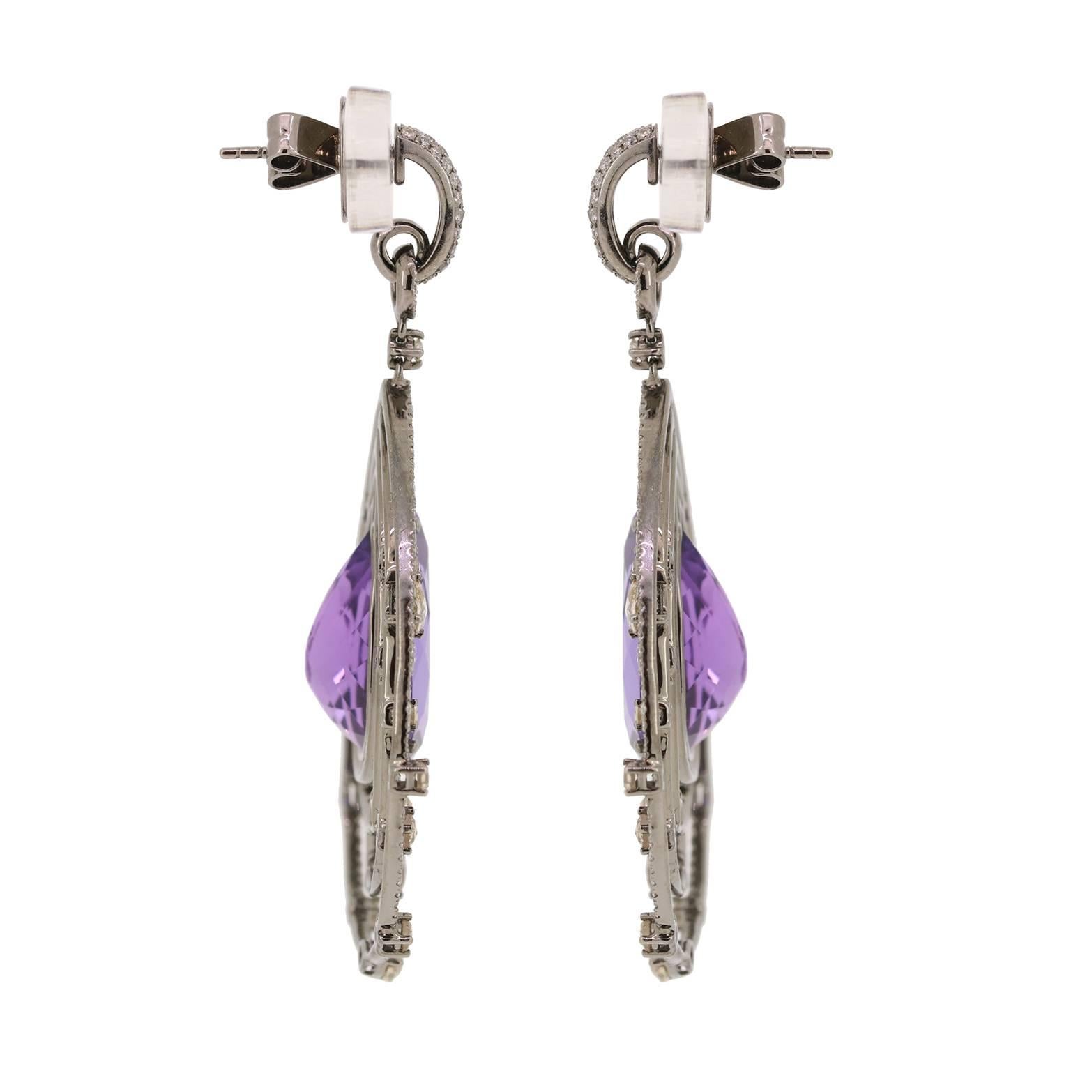 These fabulous statement earrings will sure steal the show. With a total of 26.30cts of pear-shaped Amethyst surrounded by rose cut brown diamonds (2.74cts) and pave diamonds (2.77cts) there is a sparkle from every angle.  Post / Clutch

Length -