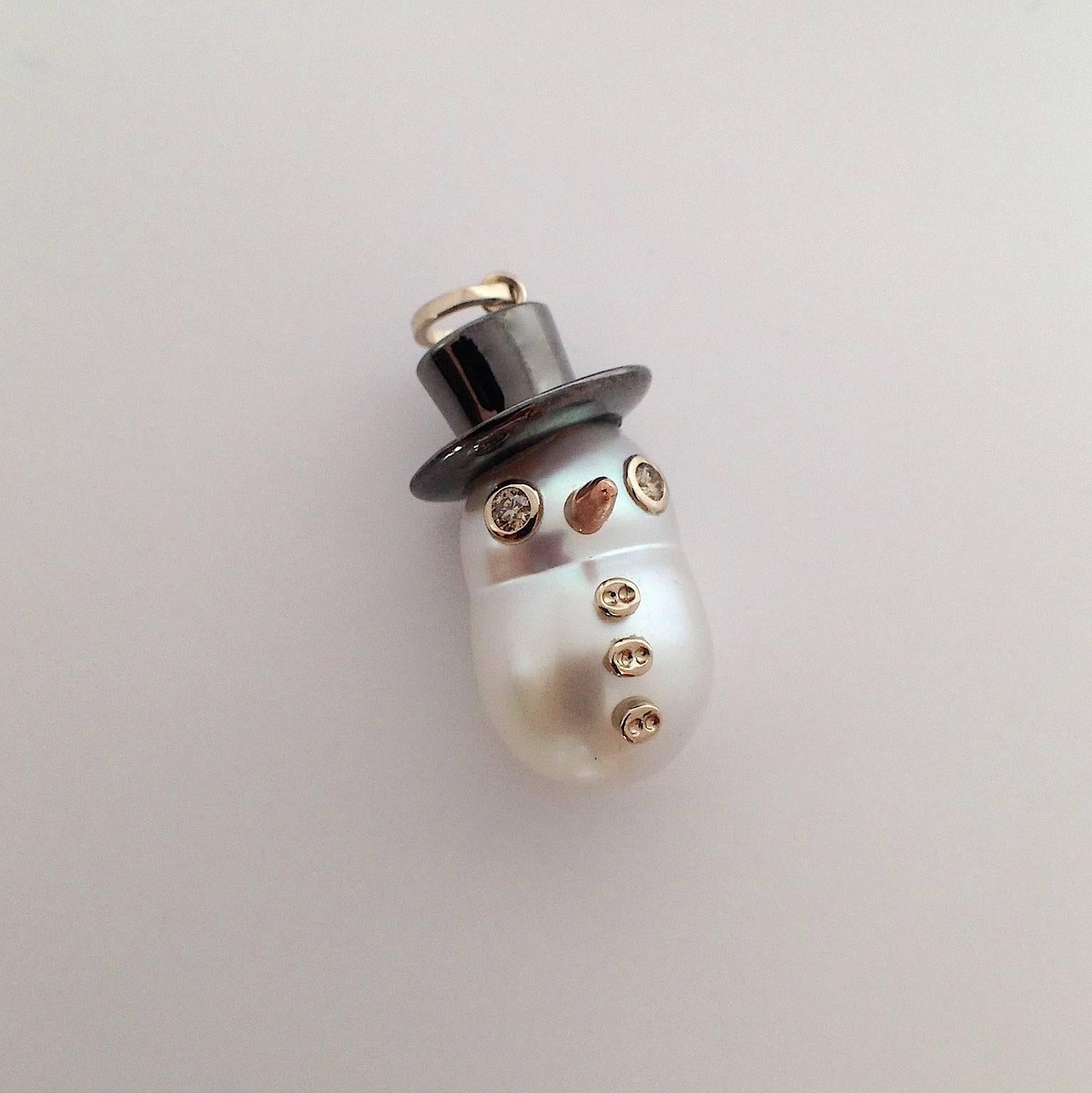 I wanted to create for the winter time a new pendant with an Australian pearl.
Its special shape inspired me to create a snowman.
It has a cylinder hat  plated black rodhium. 
Its eyes are two brown diamonds, in total ct 0,06.
Its carrot nose is in