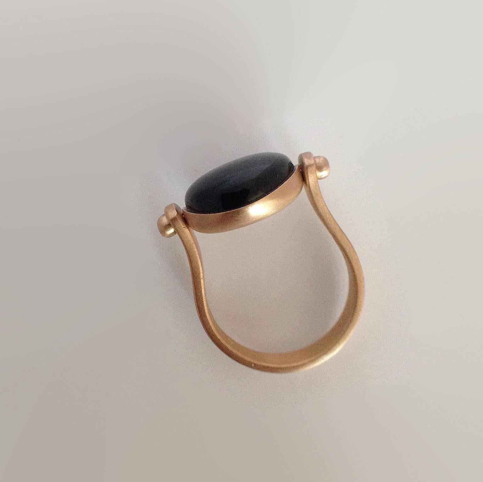 This ring is inspired by ancient Roman jewelry. They used to wear a ring where its head would be round. There's a black round jade as a button above and if you turn it around you'll have only gold where you can engrave a short phrase like a motto or