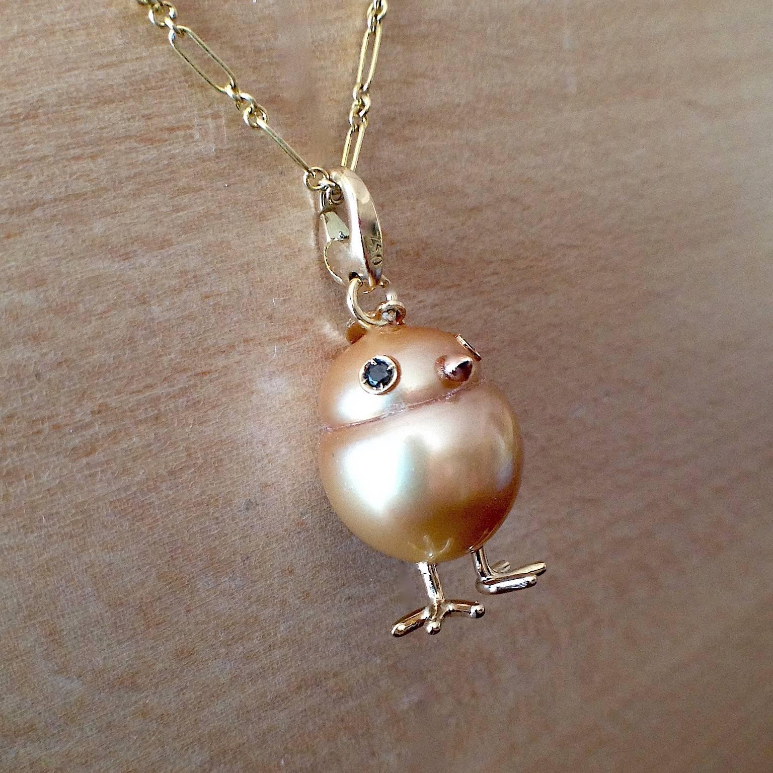 A big yellow Australian pearl has been carefully crafted to make a chick. He has his two legs, two eyes encrusted with two black diamonds and his red gold beak.
The ring of the necklace is a carabiner so it can be worn also as a beautiful charm on a