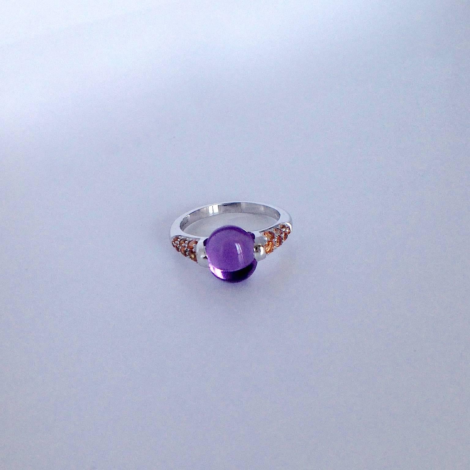 This ring in white gold has an amethyst cabochon cut and along the side there are a  total of 0.49 ct of orange sapphires.
This ring was designed in my workshop in Verona, Italy. All the materials are natural and sourced from within Italy. The