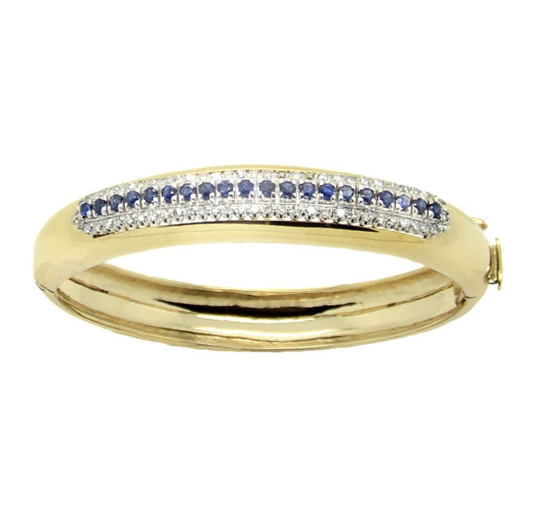 Rigid bracelet in yellow and white gold. Set with diamonds with a weight of circa 0.64 carats and sapphires circa 0.60 carats. Circa 1 cm broad. Medium size. Weight 37.10 g.