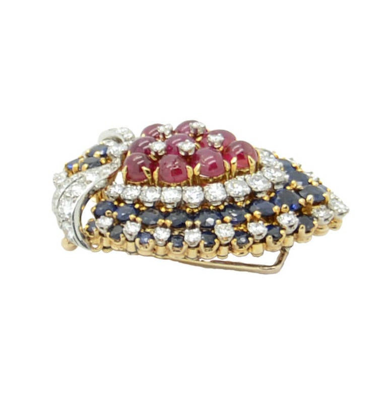 1950-1960's. Yellow gold 18K. Cabochon rubies with a total weight of circa 6.00 carats, sapphires with a total weight of circa 15 carats and diamonds with a total weight of circa 3.00 carats. Height 4.2 cm, wide 3.2 cm. Firmed Bulgari.