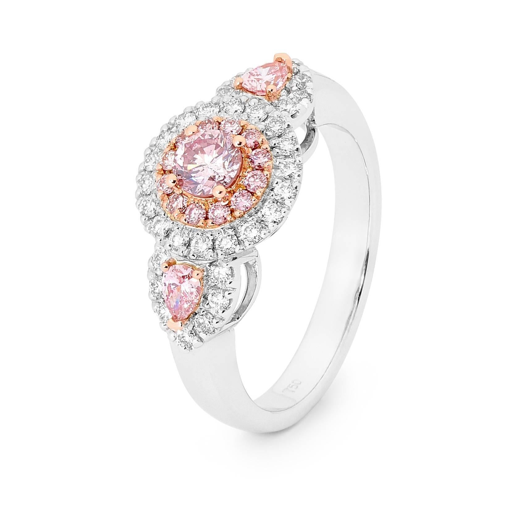 Two tone 18 carat white gold and rose gold 3 stone diamond ring. The ring consists of 1 round cut pink diamond weighing 0.29ct with a 7P colour and P2 clarity from Argyle lot #337500, and 2 pear shaped pink diamonds totalling 0.17ct with a 7P colour