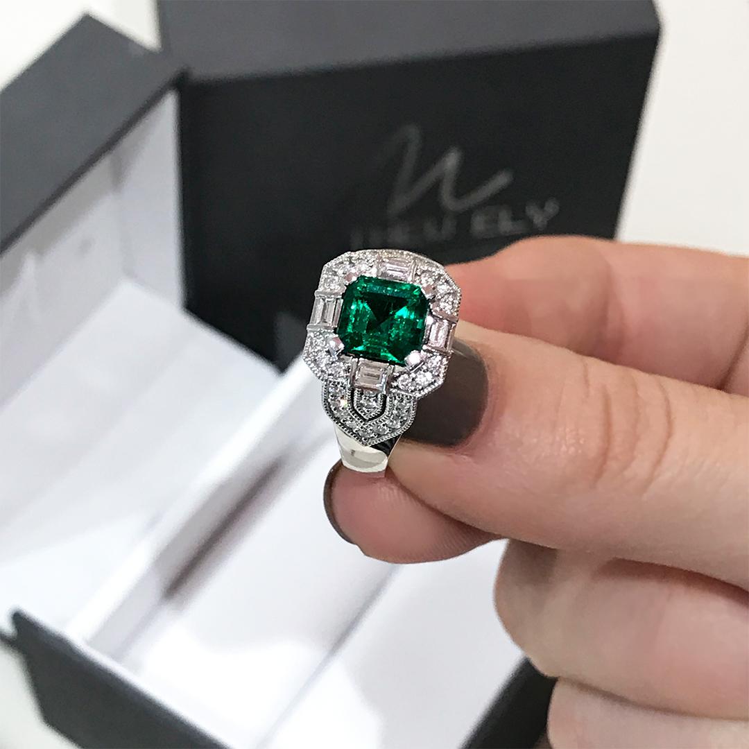 Matthew Ely Art Deco style emerald and diamond ring features a 1.70ct Square Emerald Cut Emerald with 4 divine fine white baguette (weighing 0.186ct and color F-G / VS) and 70 round diamonds (weighing 0.47ct and color F-G / SI) set in 18ct White