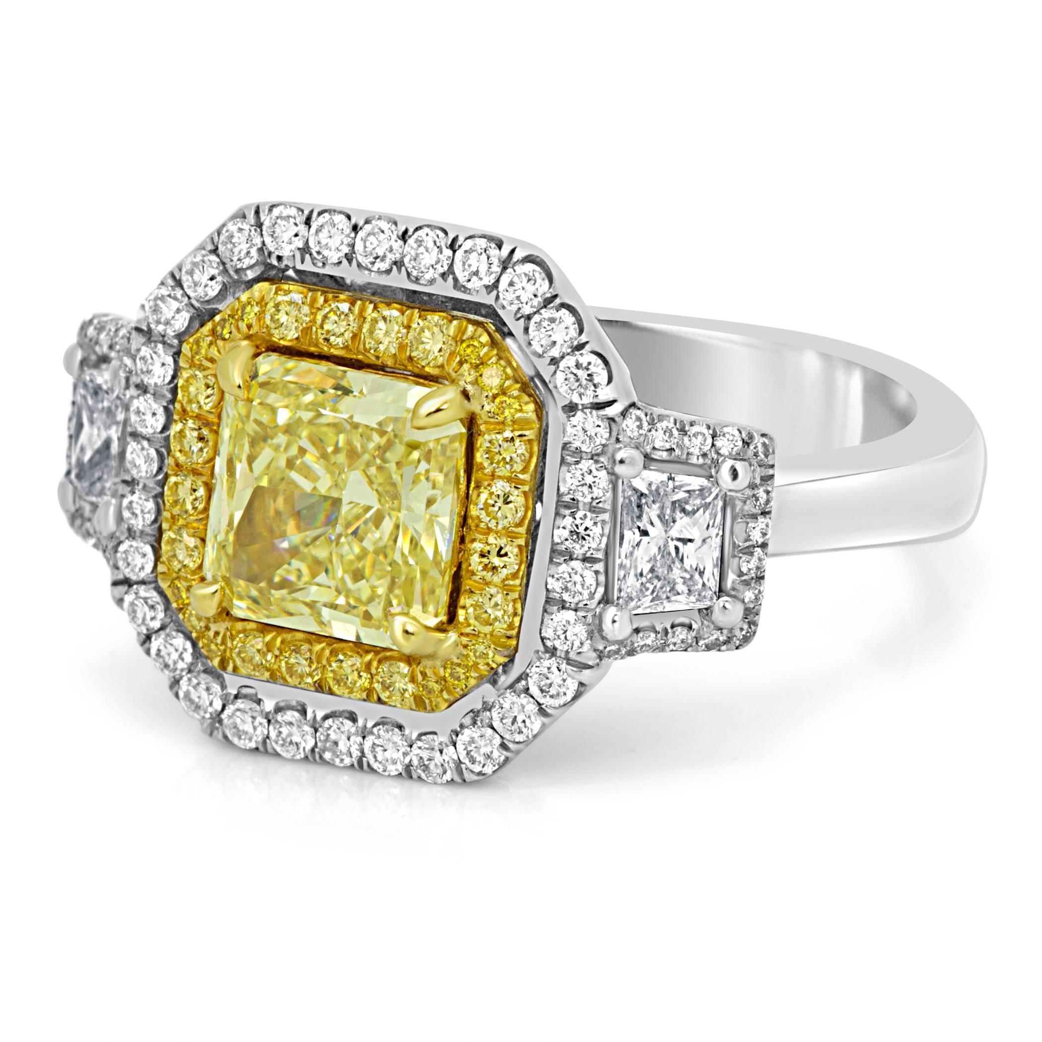 GIA certified fancy yellow Radiant cut VS2 Clarity diamond 1.63 carat encircled in double halo of natural fancy yellow diamond 0.23 carat and white diamond 0.41 carat flanked by two diamond Trapezoid 0.35 carat on the sides. In 18K white and yellow