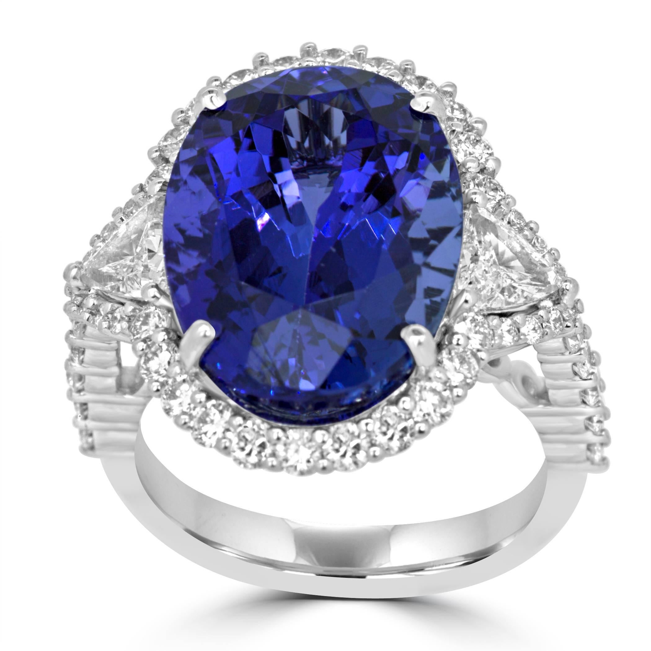 Stunning Tanzanite Oval 11.46 Carat encircled in a single Halo of White Round Diamonds 0.95 Carat Flanked by 2 Diamond Trillion 0.53 Carat on side in 14K White Gold Ring.

MADE IN USA
Total Stone Weight 12.94 Carat