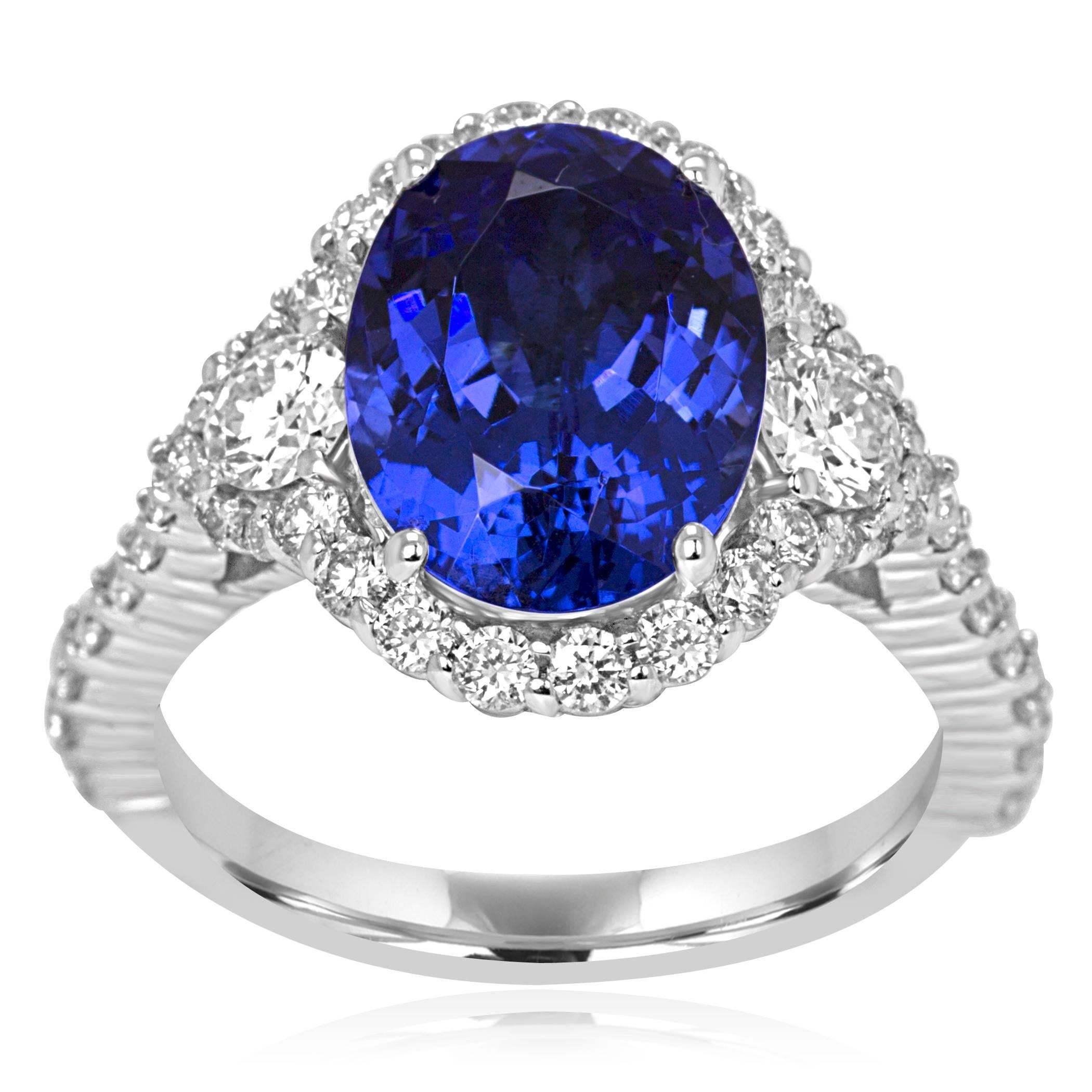 Tanzanite Oval 3.80 Carat Flanked by 2 White Diamond Rounds 0.34 Carat encircled in a single Halo of White Round Diamonds 0.79 Carat in a stunning Handmade 14K White Gold Ring.

Style available in different price ranges. Prices are based on your