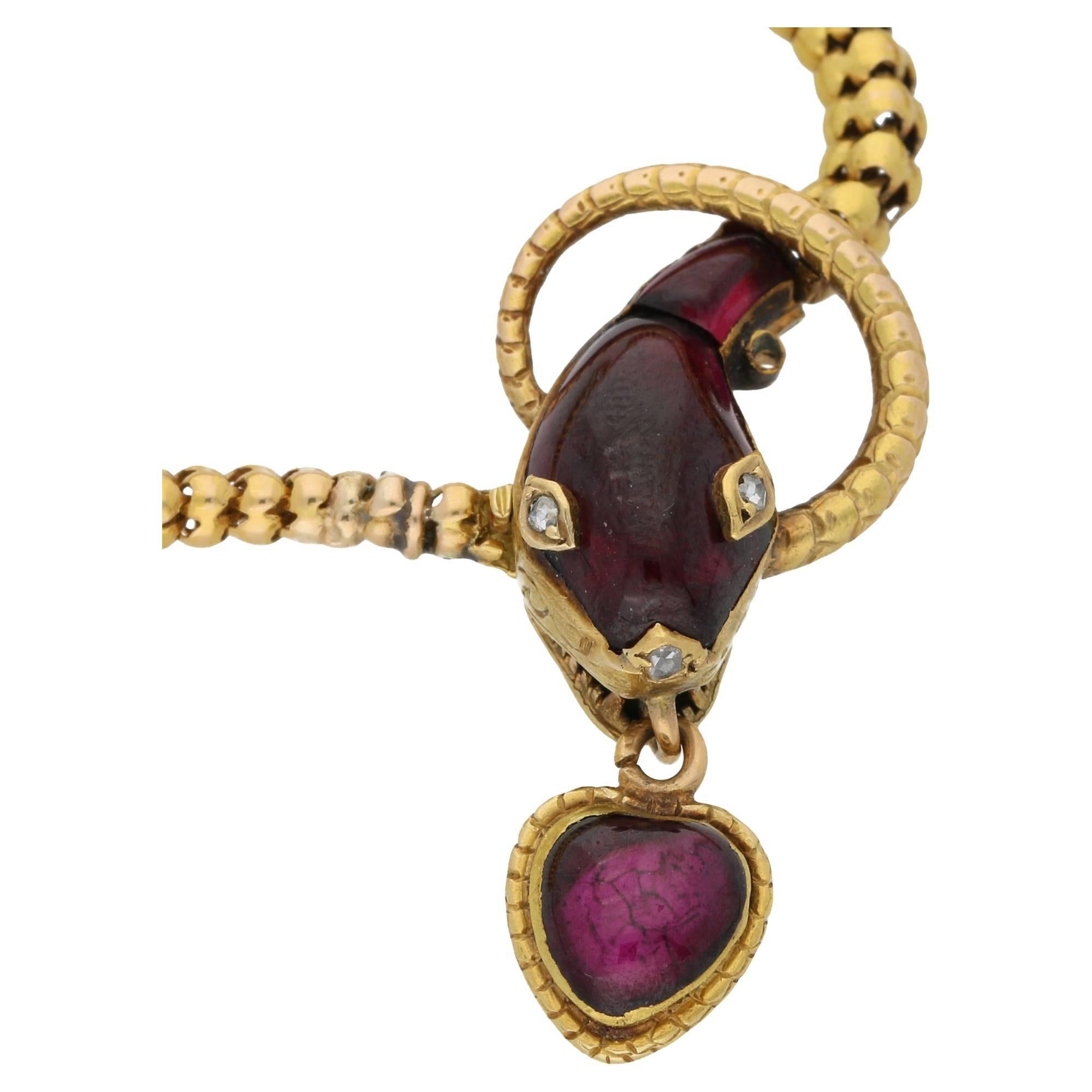A magnificent Victorian garnet snake chain necklace. Suspended from the snakes mouth hangs a small heart shaped locket, fronted with a foil backed cabochon garnet rub over set in 9ct yellow gold. The head is a free form foil backed cabochon garnet,