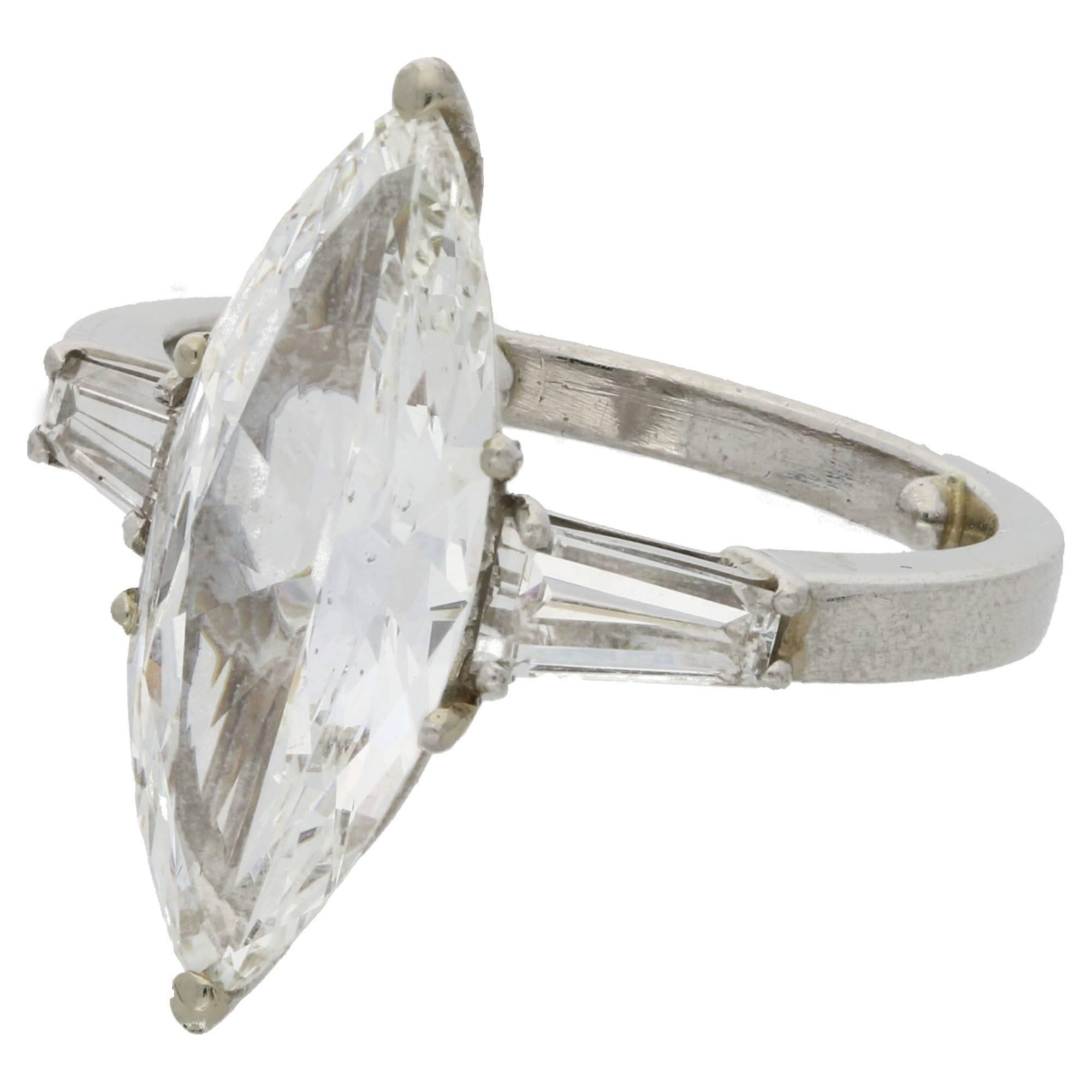 A beautiful marquise shaped diamond ring set in platinum.  The central marquise shaped diamond is independently certified as 3.26cts and graded as a rare white, G colour and VS clarity.  It is flanked by tapering baguettes each side which flow into