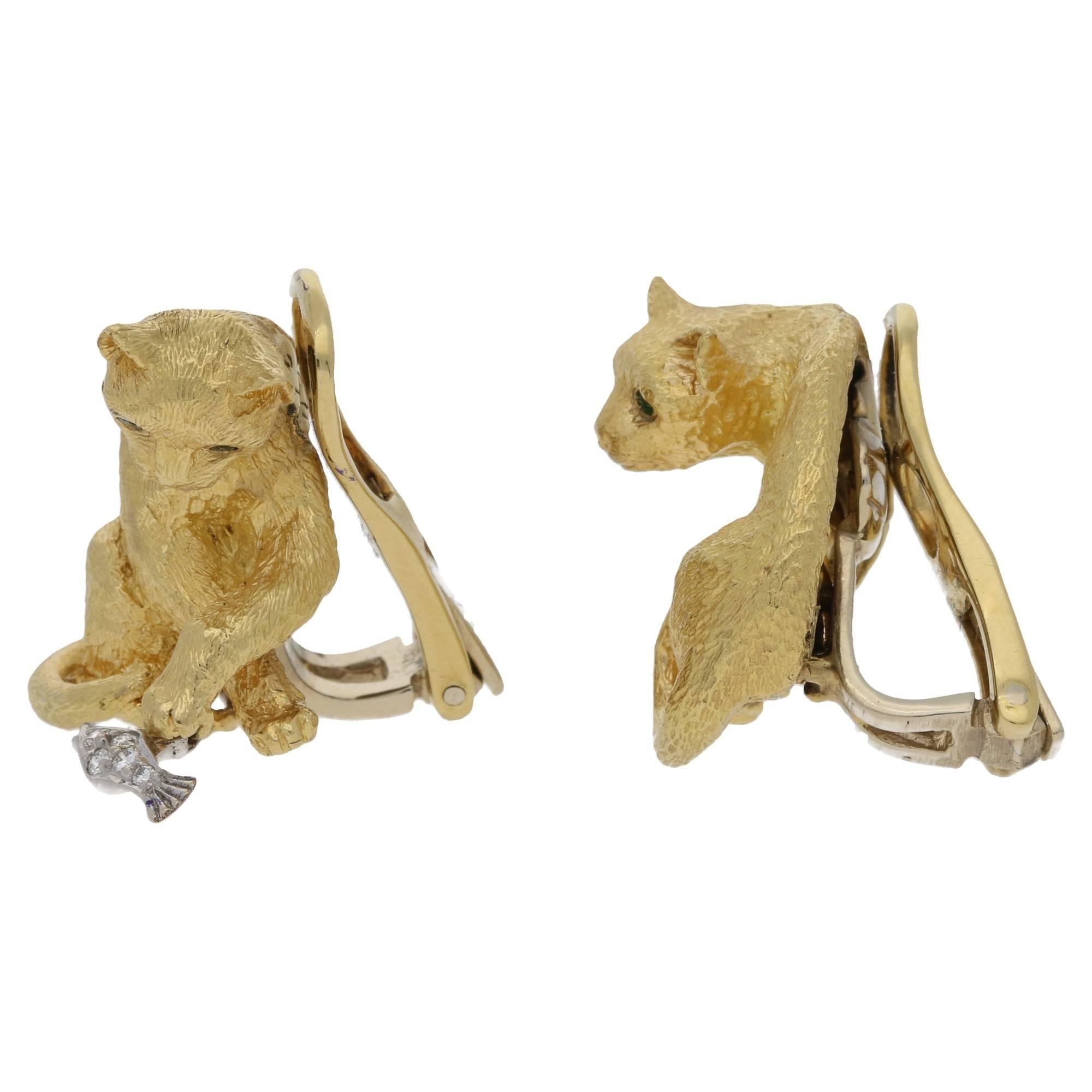 A fine pair of Tiffany 18k yellow gold cat earrings. These rare earrings take the form of two cats, one detailed with a diamond articulated fish in a white gold setting, the other a cat playing with a ball. The ball taking the form of a round