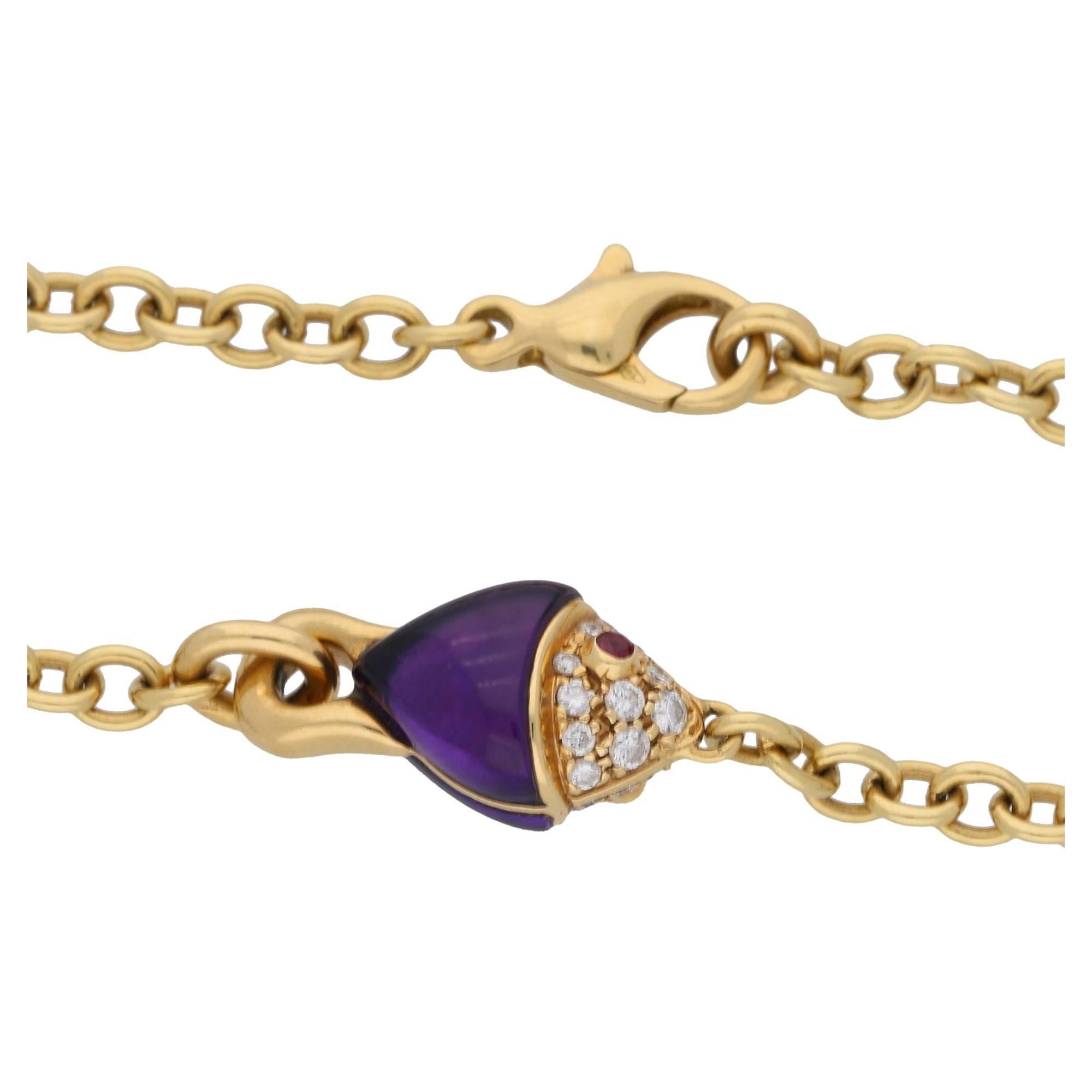 A fanciful Bvlgari amethyst, diamond and ruby fish necklace set in 18ct yellow gold. With two fantasy cabochon cut amethysts creating both sides of the fish's body embelished with a pave set round brilliant cut diamond face finished with collet set