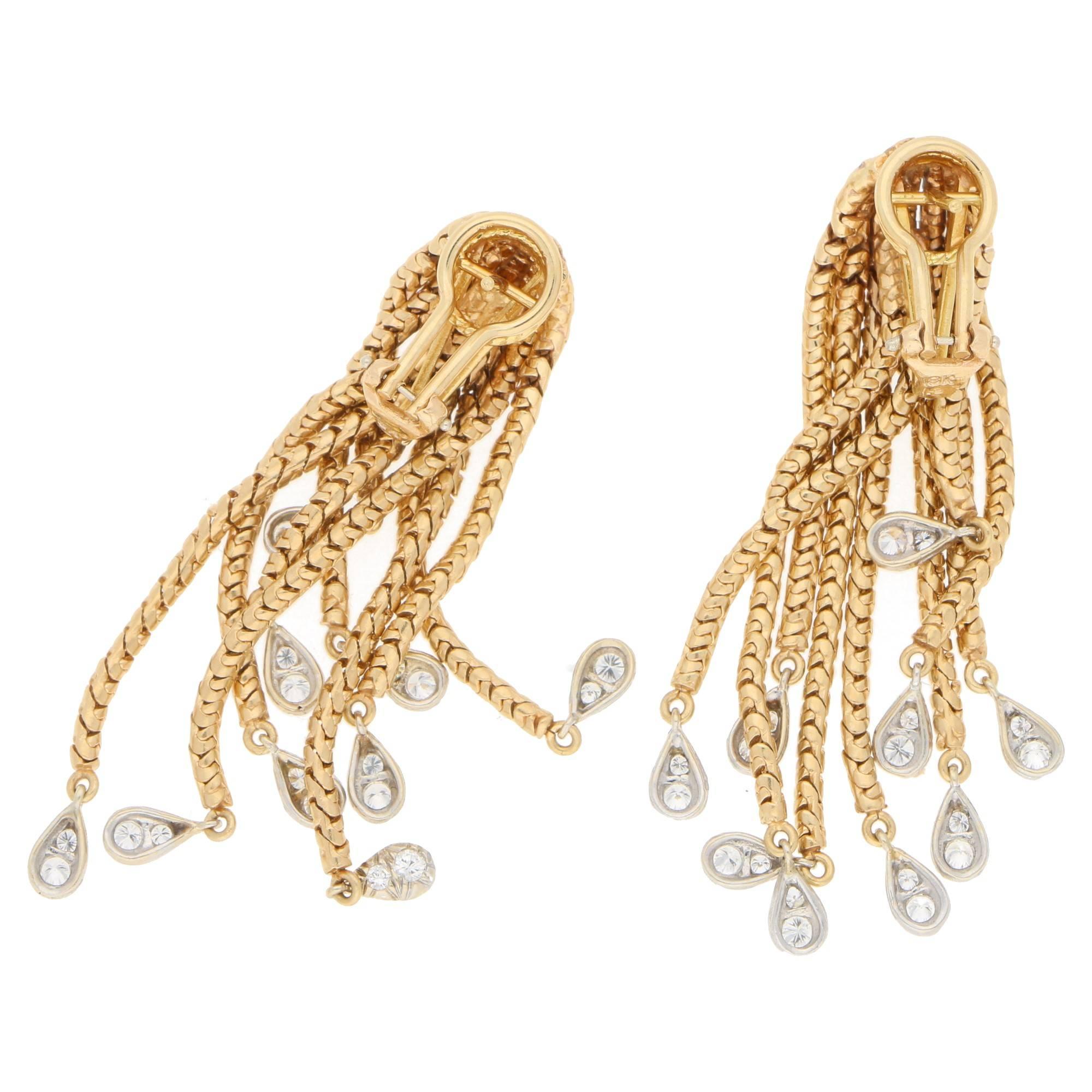 A fantastic pair of 1960's Hammerman Brothers diamond tassel earrings. Each earring is formed of nine graduated 18ct yellow gold box chain tassels merged at the crown, terminating in a platinum tear drop grain-set with two round brilliant cut
