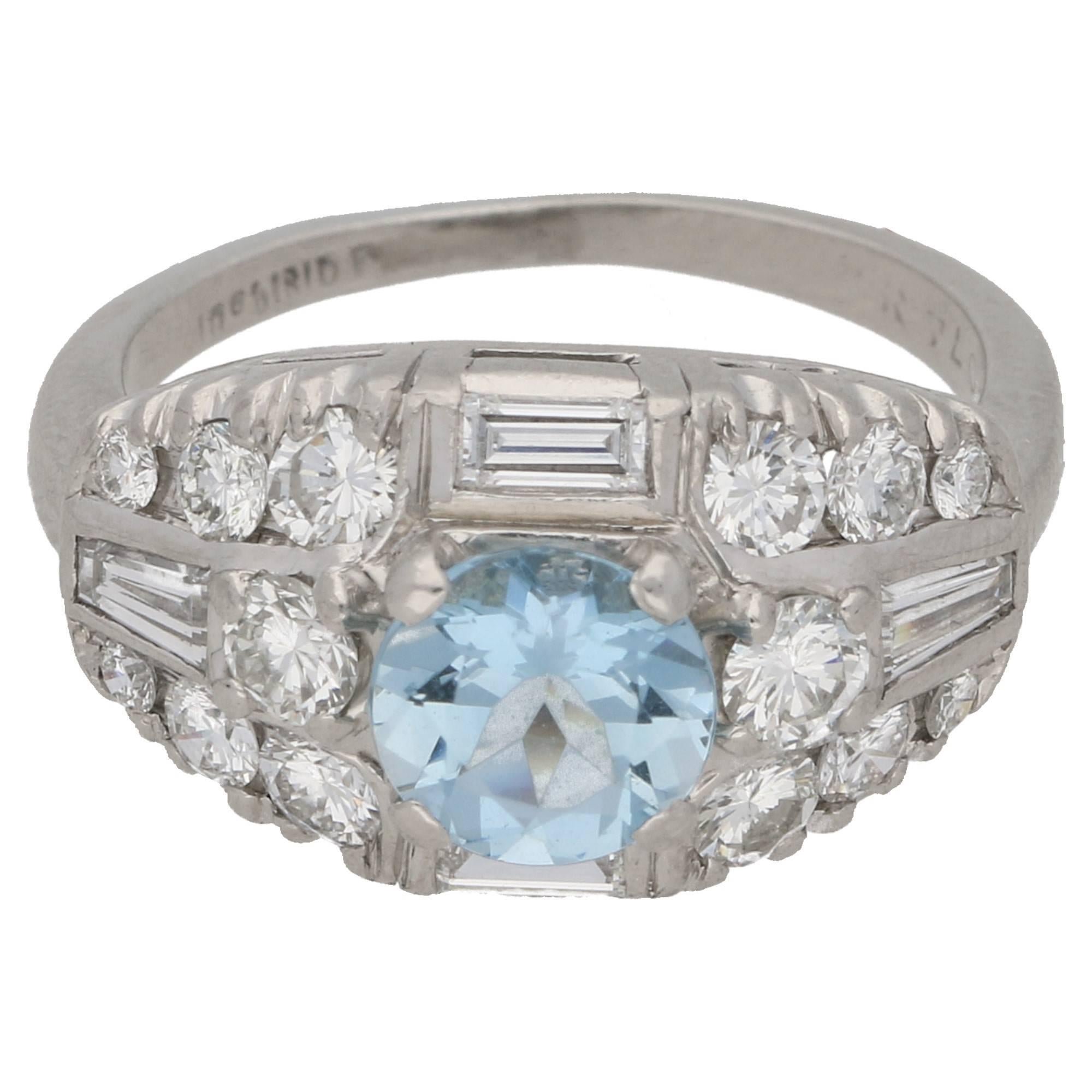 An Art Deco aquamarine and diamond bombe cocktail ring in platinum. The ring features a round-shape aquamarine four-claw-set to the centre, amidst a bombe-shape collet rubover- and claw-set throughout with baguette-cut, tapered baguette-cut,
