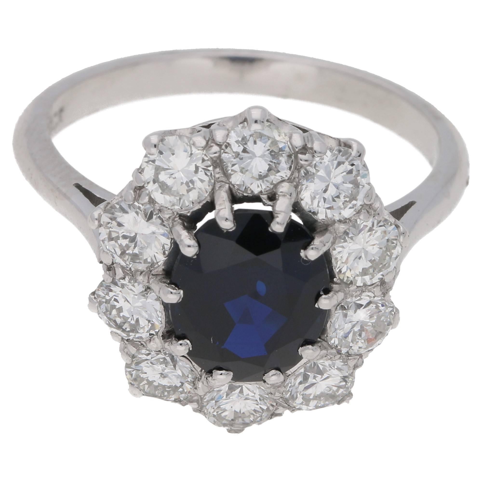 Estimated sapphire weight: 2.13cts. Estimated total diamond weight: 1.20cts. Assessed diamond colour: H. Assessed diamond clarity: VS.
A classic oval sapphire and diamond cluster ring set in 18ct white gold. 
The centrally set sapphire is ten claw