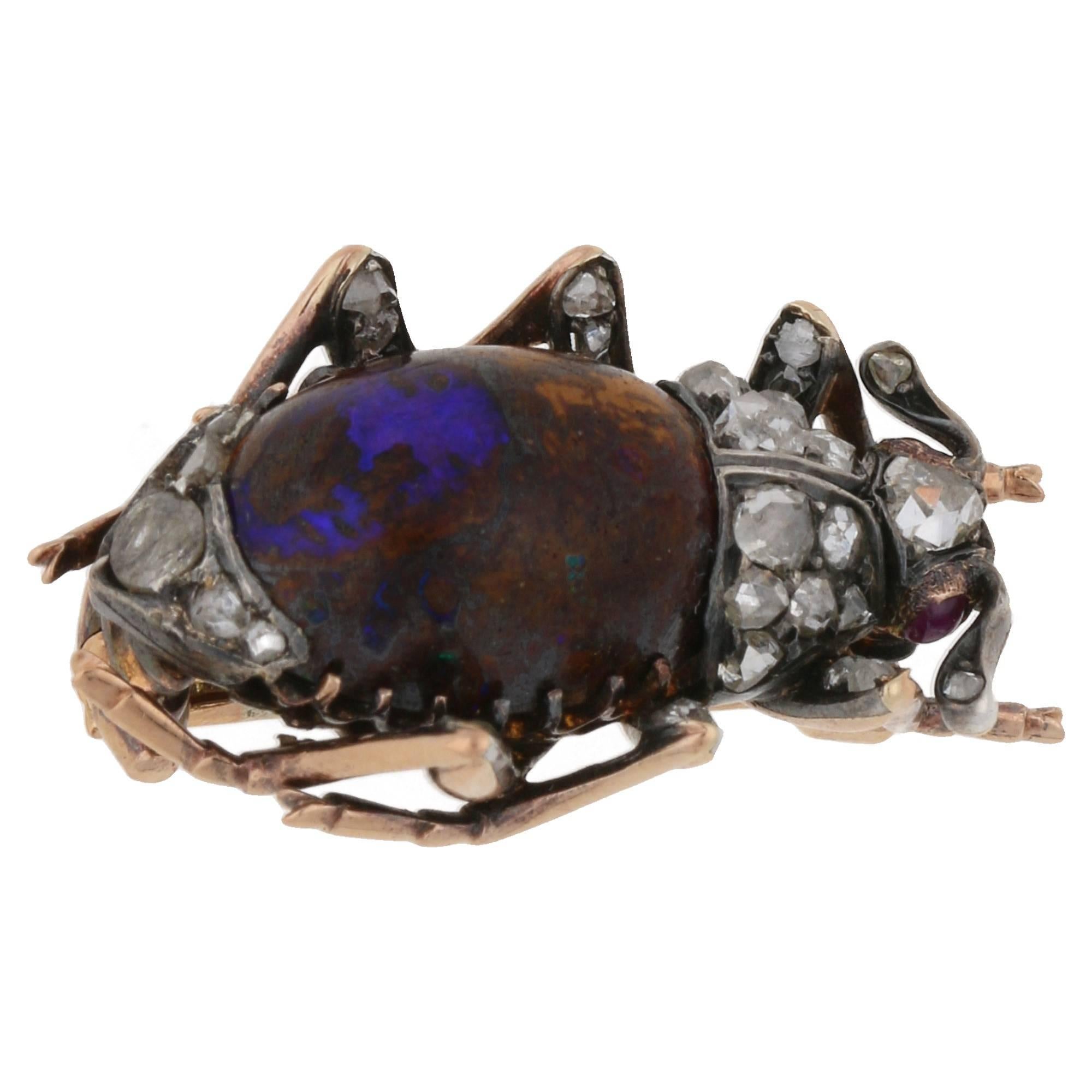 A delightful Victorian boulder opal and rose cut diamond bug brooch set in silver on gold. The abdomen is an unusual blue boulder opal claw set between 9ct yellow gold legs topped in silver set with rose cut diamond accents. The thorax is grain set