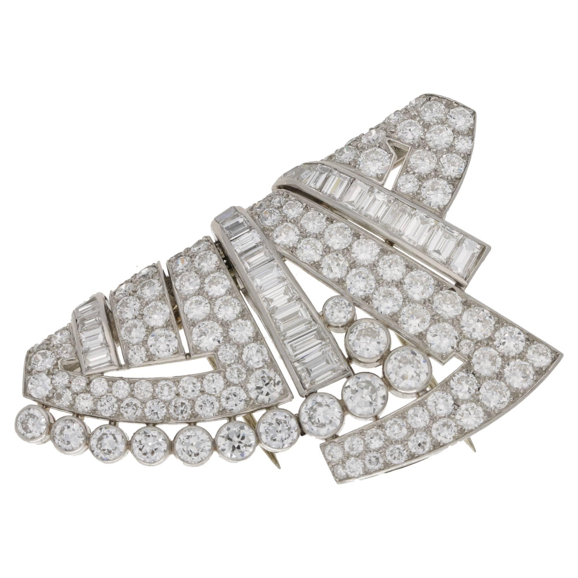 A substantial geometric design diamond set brooch set in platinum and gold. The brooch is French in origin, designed circa 1930's. The brooch is formed of 106 round cut pave set diamonds, 12 round cut diamonds rub-over set and 25 calibre cut