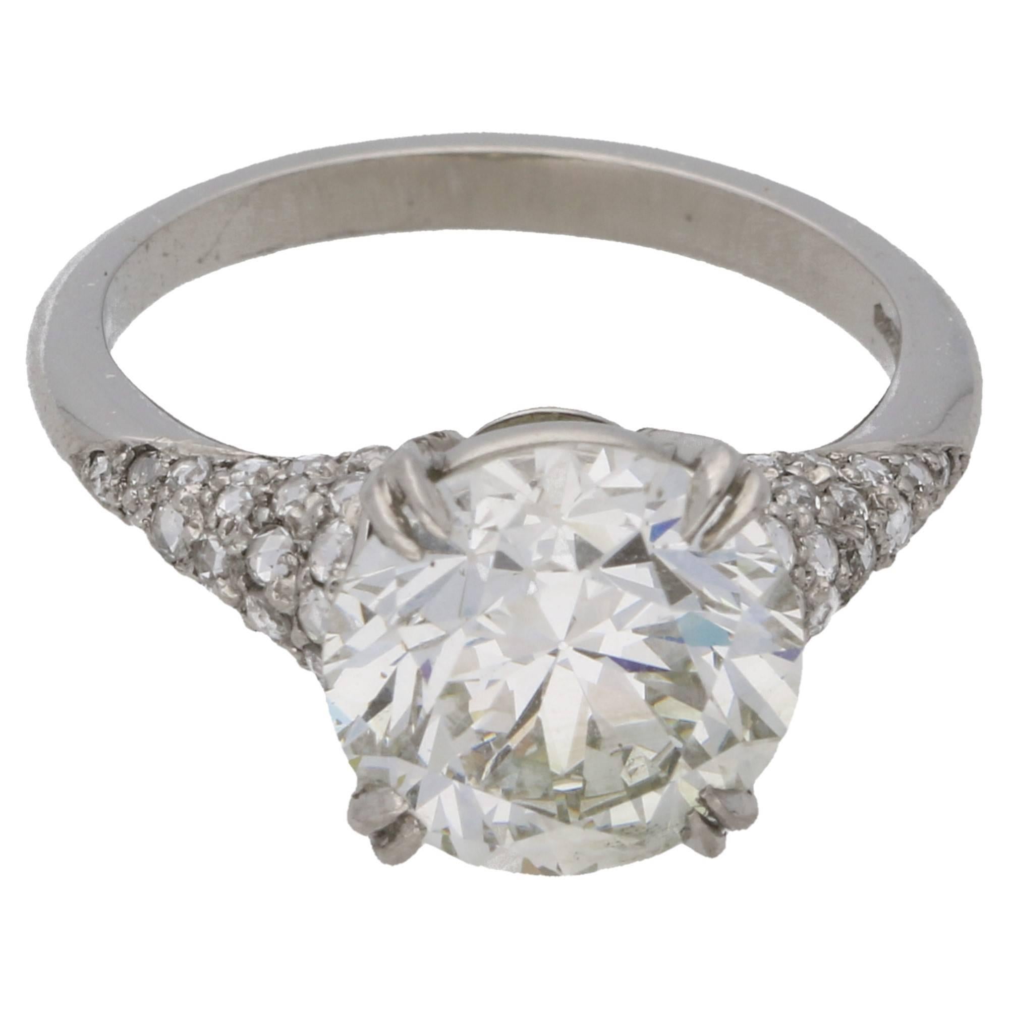 A contemporary platinum single stone ring, featuring a re-faceted Old European cut diamond independently certified as 4.18ct K colour and SI1 clarity, set in a double four claw double gallery setting with grain set rose cut diamond shoulders to a