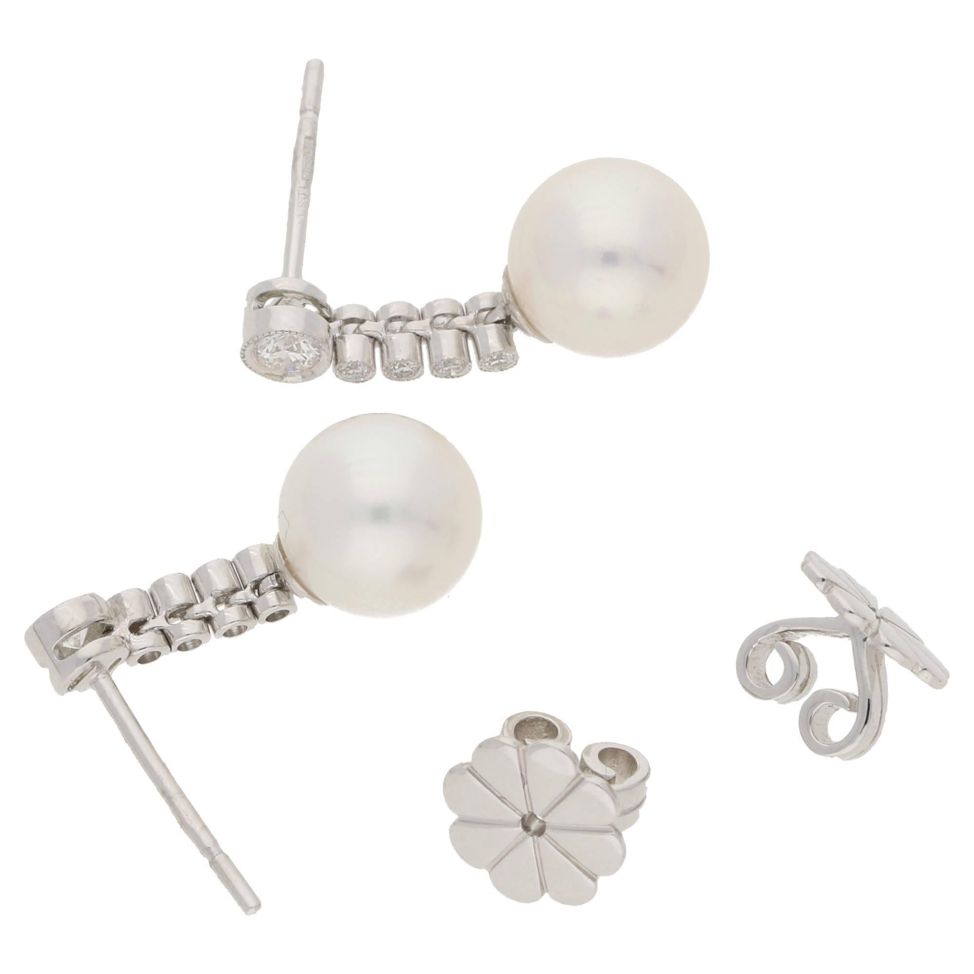 A smart and stylish pair of freshwater round pearl drop earrings, set with diamond detailing in the drop segments. The diamonds totaling 0.29cts are bezel set in 18k white gold, with delicate edge detailing. On classic post and butterfly fittings.