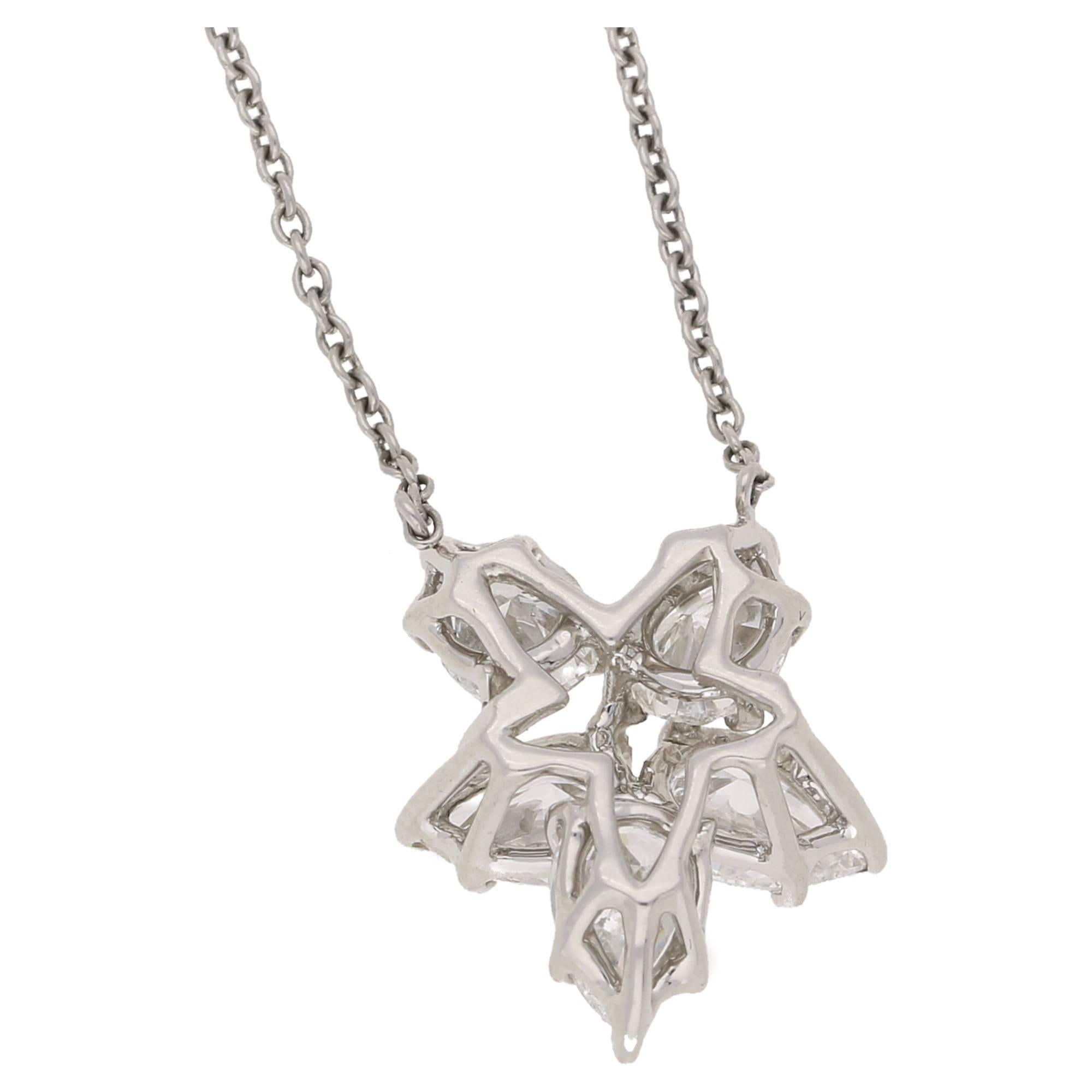 A beautiful Winston Cluster by Harry Winston diamond cluster pendant, featuring five pear shaped diamonds set in fine five claw double gallery settings at varying angles to form a floral cluster shape. The pear diamonds are approximately G/H colour
