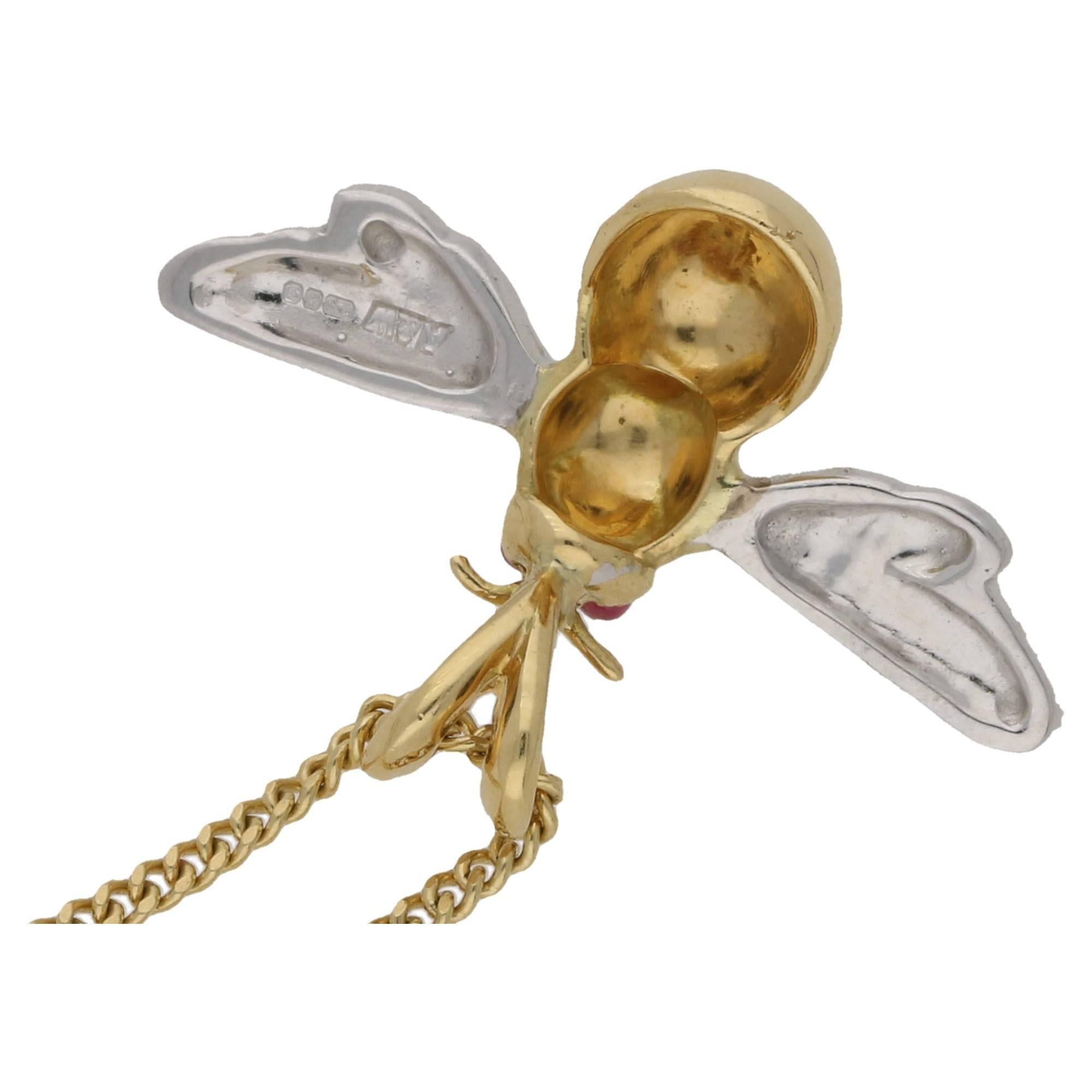 A sweet 18k gold bee pendant, with fine detailing on the body and wings. The eyes are made from vibrant red cabochon cut rubies.  In a wonderfully contrasting mixture of white and yellow gold; this pendant measures 30mm xs 20mm. It hangs on a neat