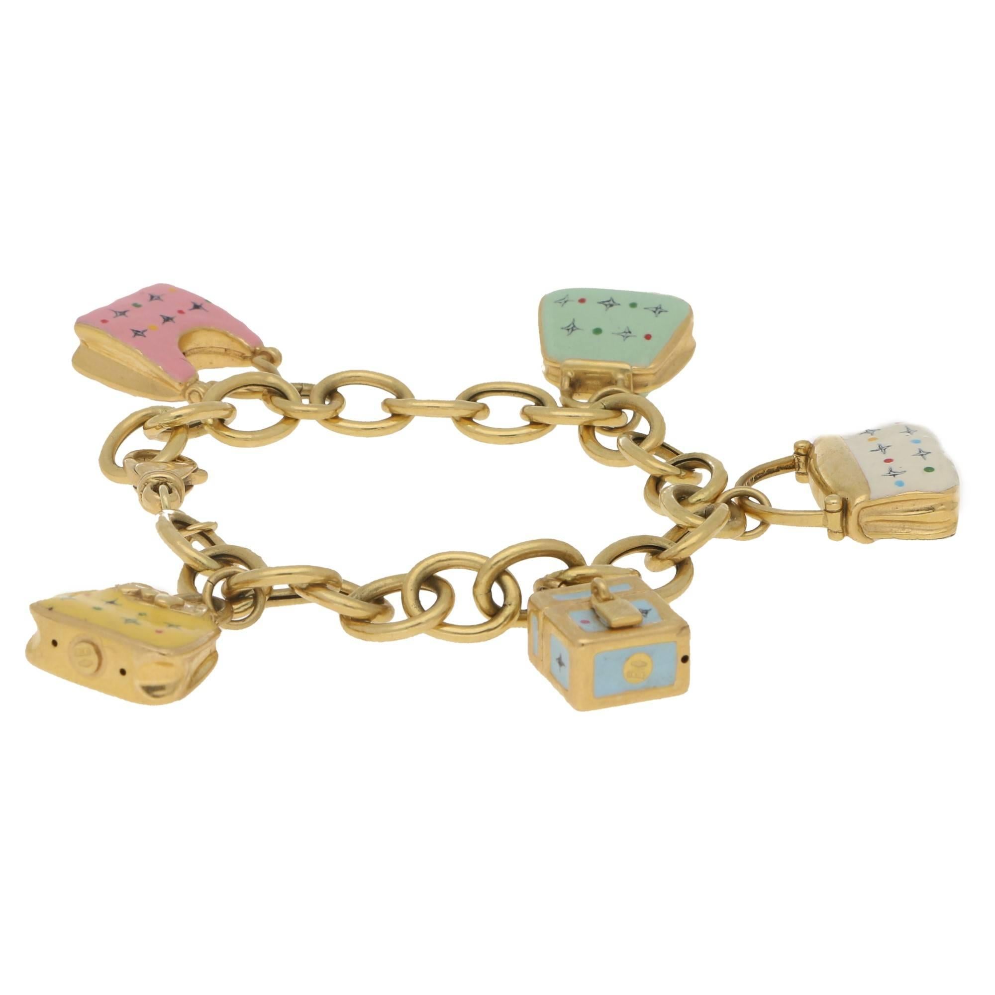 A quirky 18k gold bracelet set with five detailed handbag charms. Each charm is unique in colour and design, with fine enamel work detailing. On a chunky secure lobster clasp. Length 7.5 inches total.