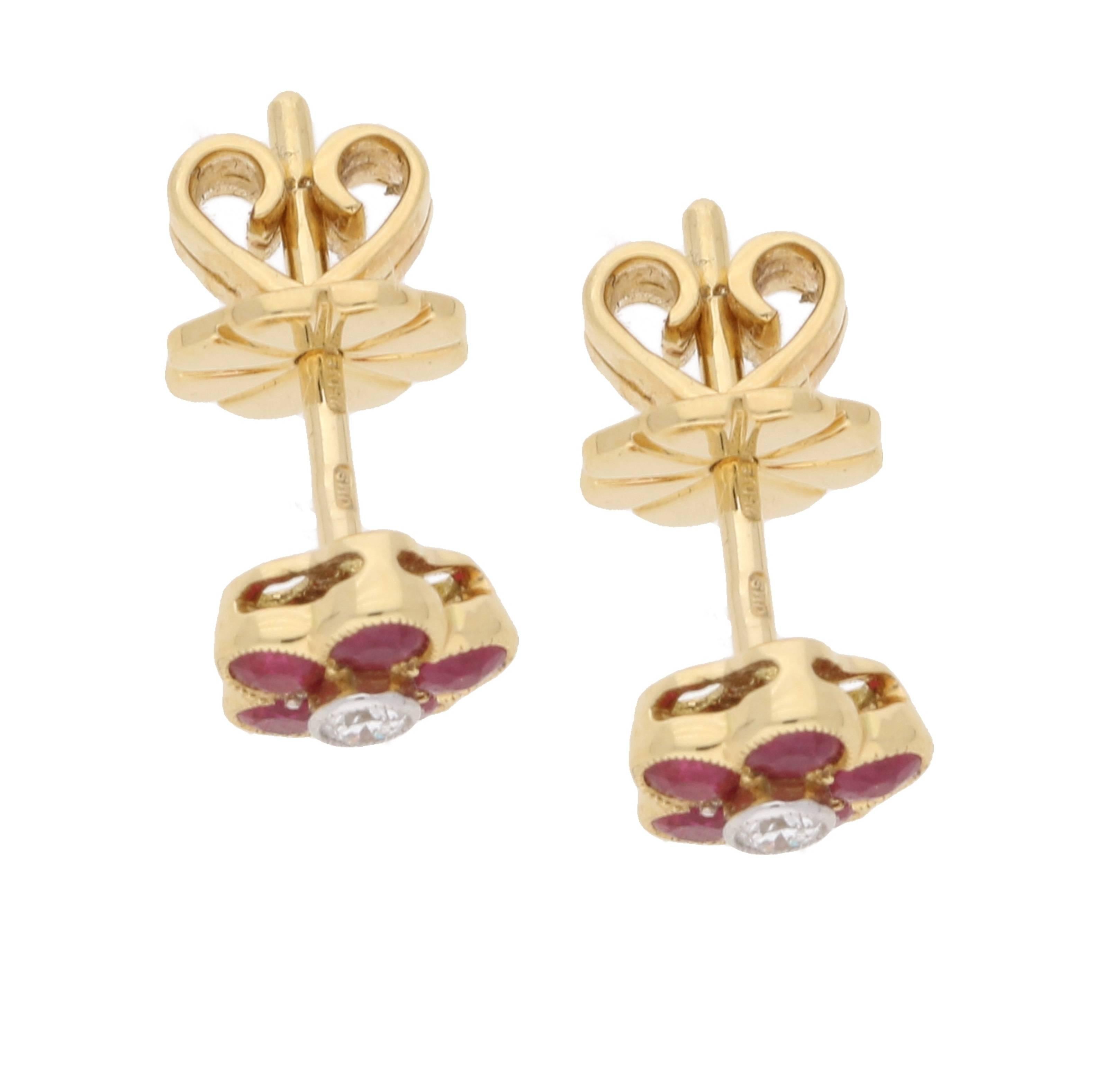 A sweet pair of floral stud earrings, detailed with five rubies surrounding a central diamond, 18ct gold and have beautiful mille grain edge detailing to the settings. These are on post and butterfly fittings. They come in a smart Susannah Lovis