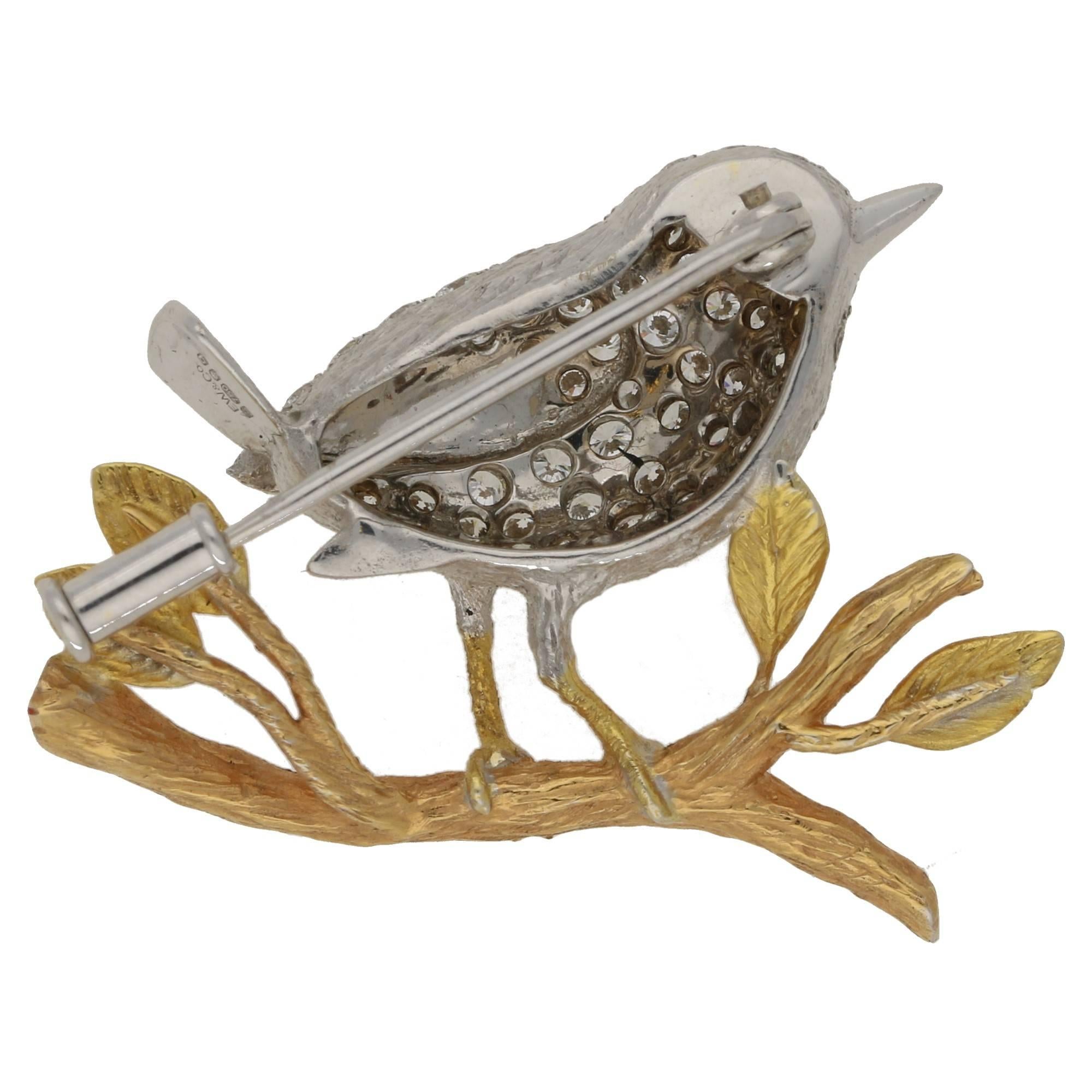 A modern diamond set brooch depicting a wren on a branch, beautifully detailed. This brooch is set with approximately 1.2cts diamond, colour: F-G, clarity: VS. In 18ct white and yellow gold, carrying full hallmarks.