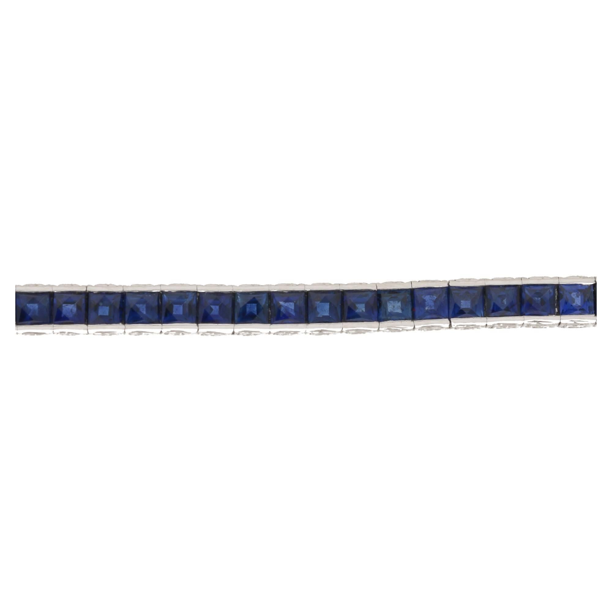 A stunning platinum sapphire line bracelet, featuring seventy-five vivid-blue french cut sapphires each set in a two bar setting individually hinged to the next sapphire creating a seamless line of sapphires seemingly invisibly set with beautiful