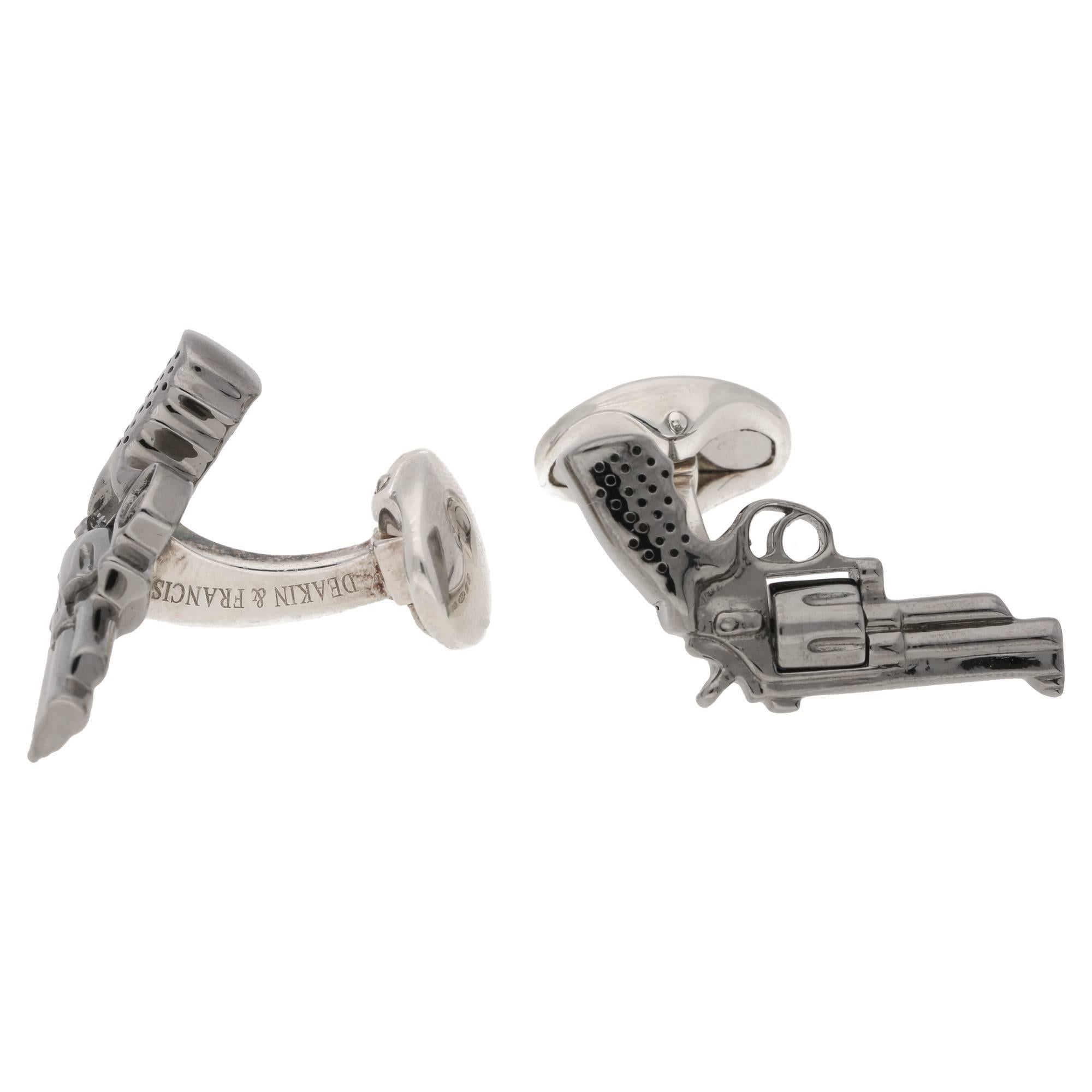 A pair of British 925 Sterling Silver and hand painted enamel sprung revolver cufflinks. The detail is wonderful, the barrel even spins! These are set on a small domed oval spring link fitting.
