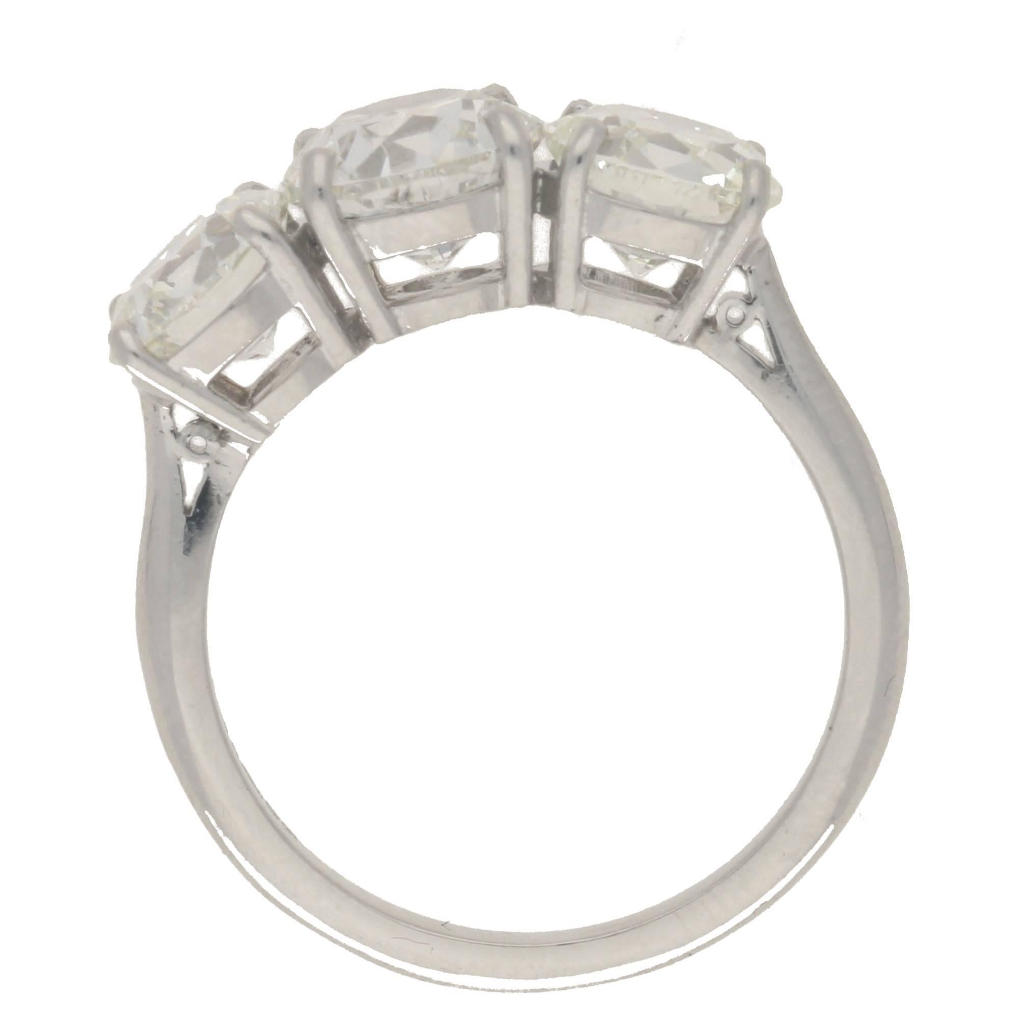 The diamonds are independently certified by the IGI as: 1.59ct G/Si2, 1.10cts G/Vs2 and 1.26ct I/Vs2. Total carat weight: 3.95cts.
An exceptional three stone diamond ring set in platinum, with three Old European cut diamonds in four claw double