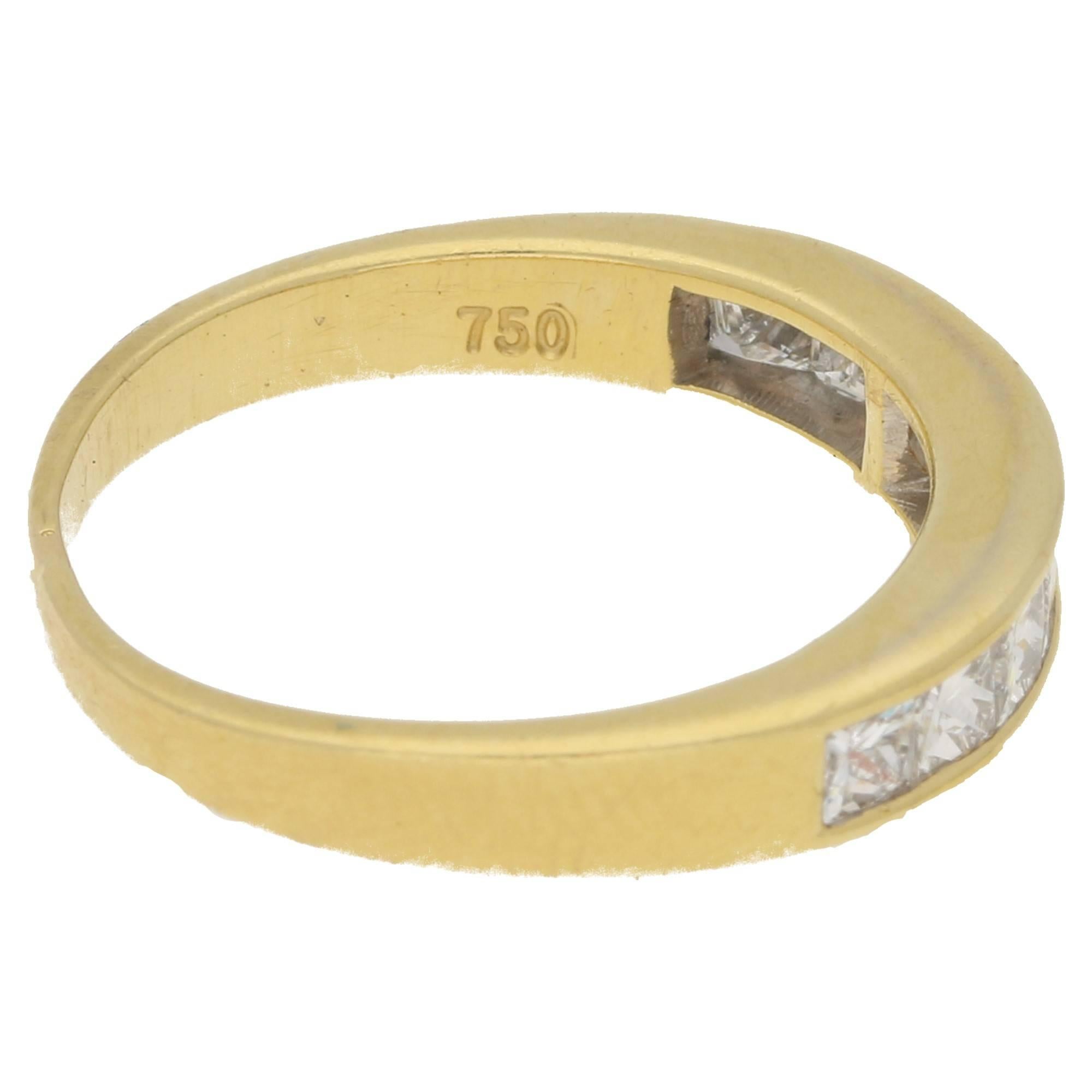 A half eternity ring with nine princess cut diamonds channel set in 18ct yellow gold. The shank tapers to a narrower reverse. Estimated total diamond weight: 0.79cts. Assessed diamond colour: H/I. Assessed diamond clarity: VS2. This ring can be