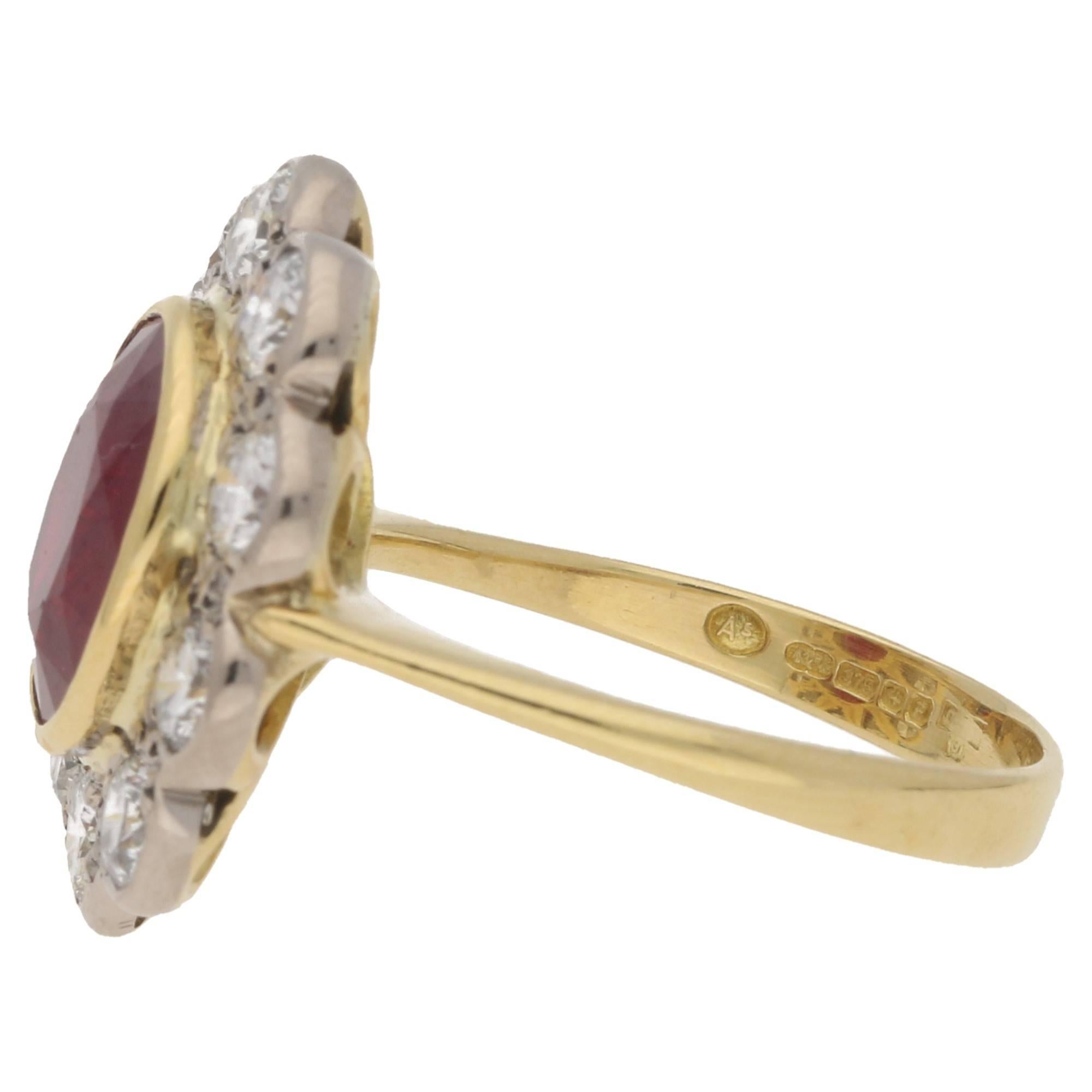 A ruby and diamond floral cluster ring. The ring is formed of one oval faceted ruby centrally set in a yellow gold rub-over setting. The ring is further embellished with ten round brilliant cut diamonds in a white gold rub-over setting forming the
