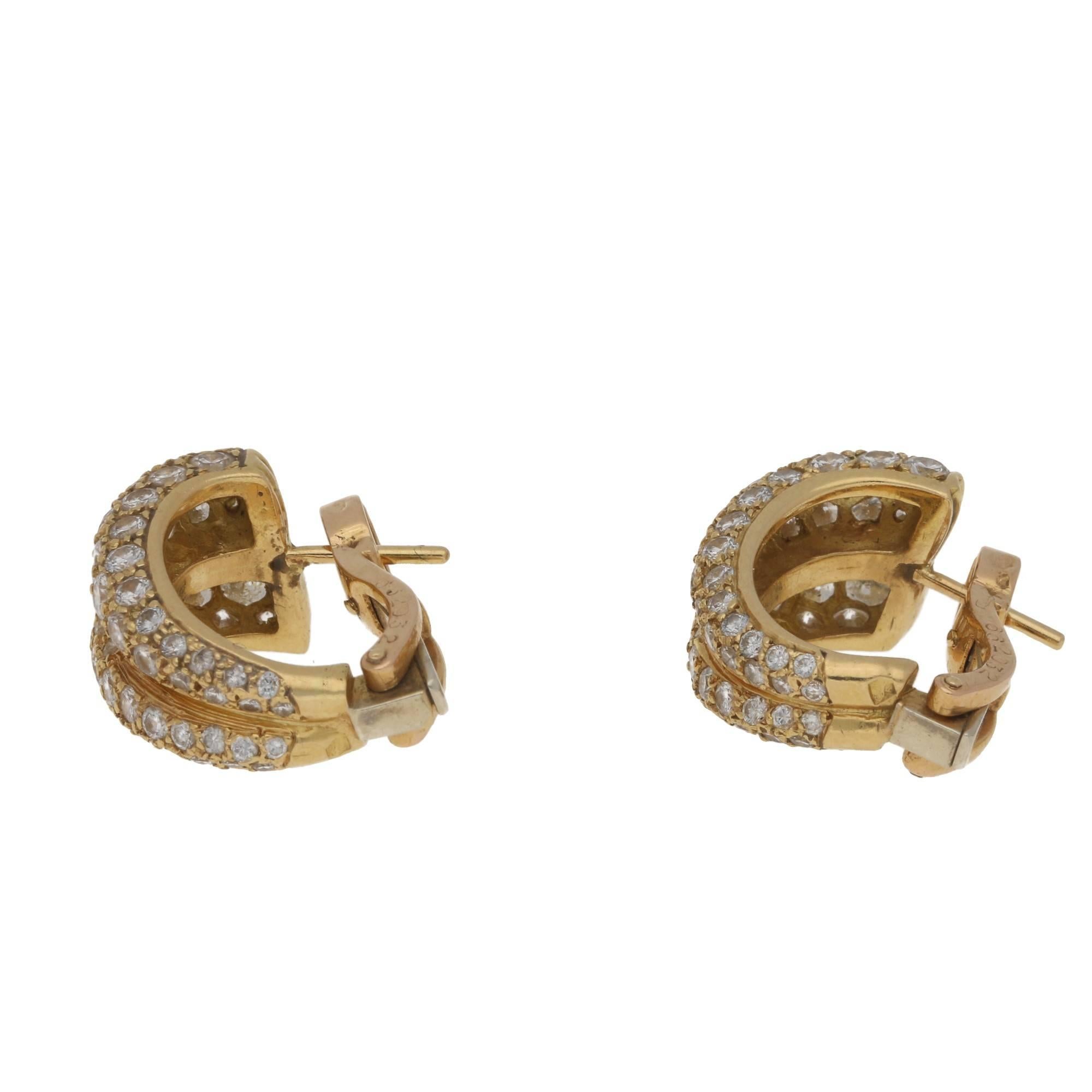 These  fabulous earrings by Cartier feature a double hoop design set with round brilliant cut diamonds. The diamonds totaling approximately 2.30ct, estimated colour E-F and clarity VVS. These are made in 18k yellow gold. These come with their