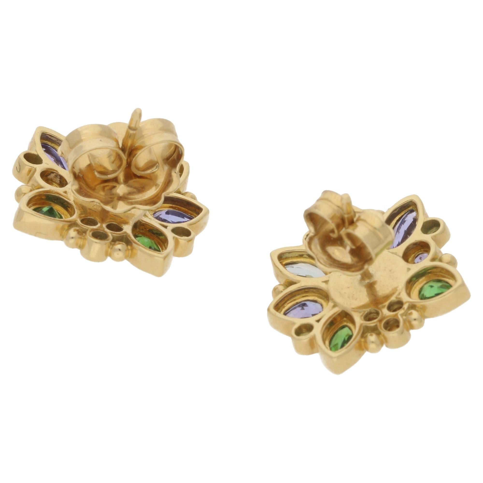 Temple St Clair for Anima collection stud earrings set in 18ct yellow gold, featuring rubover set moonstone, tsavorite garnets, tanzanite, aquamarine and diamonds in a cluster design with signature granulation, to a post and butterfly fitting.