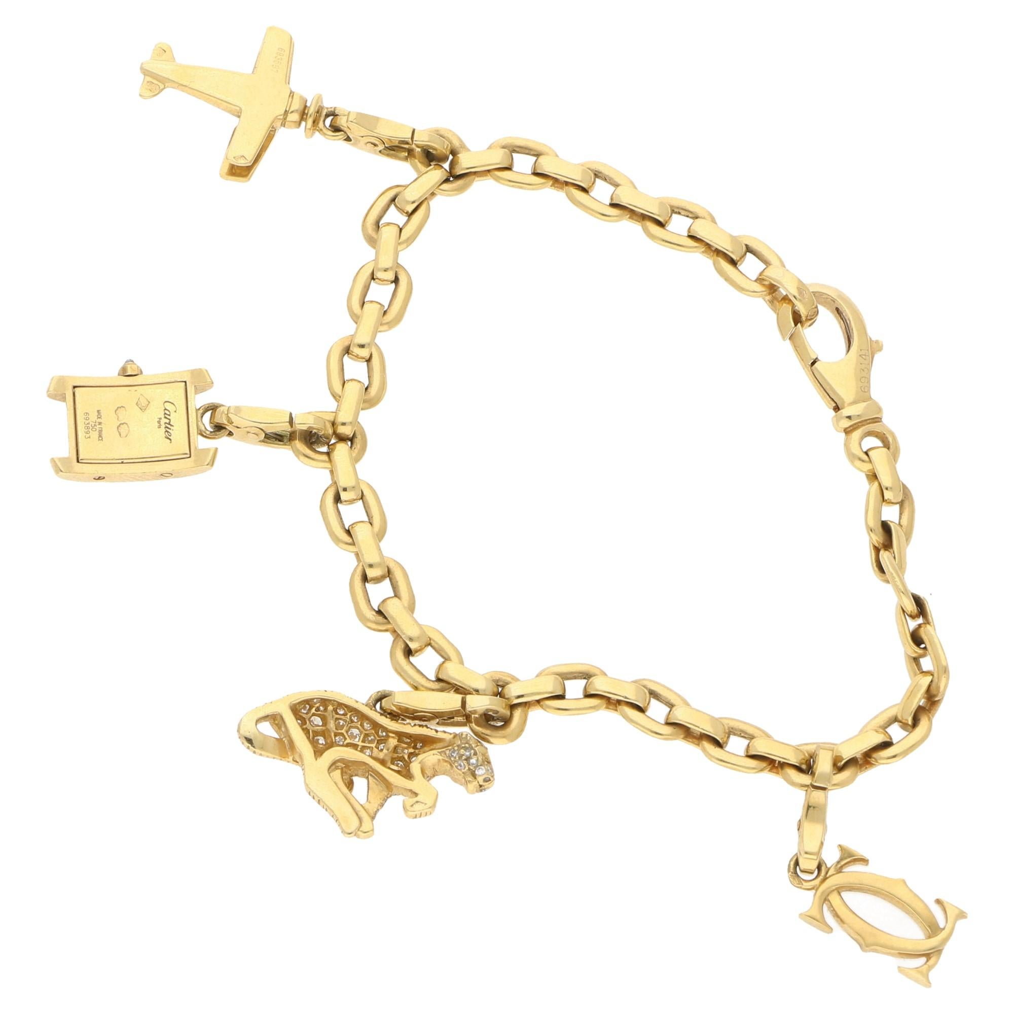 A Cartier charm bracelet in 18-karat yellow gold, with all the charms also in 18-karat yellow gold. The bracelet is designed as a trace link chain fitted with a lobster clasp fitting and is adorned with four emblematic Cartier charms with similar