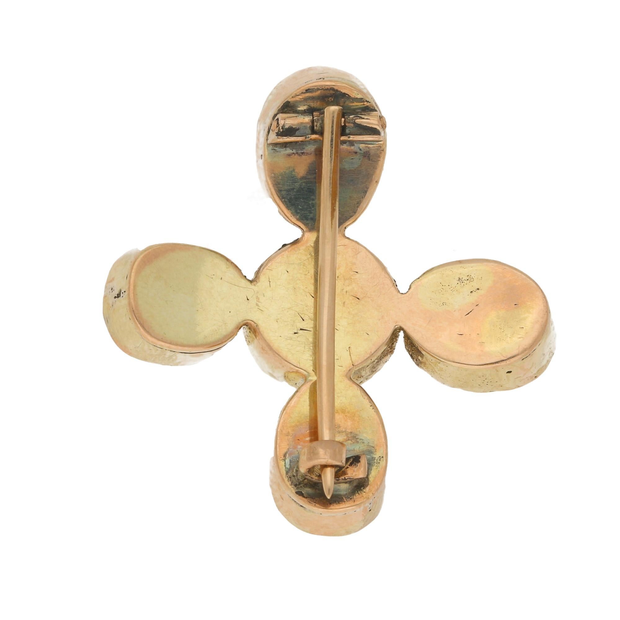 An antique amethyst cross brooch in yellow gold, designed as a cross formed of five round, oval and cushion-shaped amethysts.
All are rubover-set in closed back yellow gold settings, and fitted to the reverse with a pin and C-shape hook fitting.