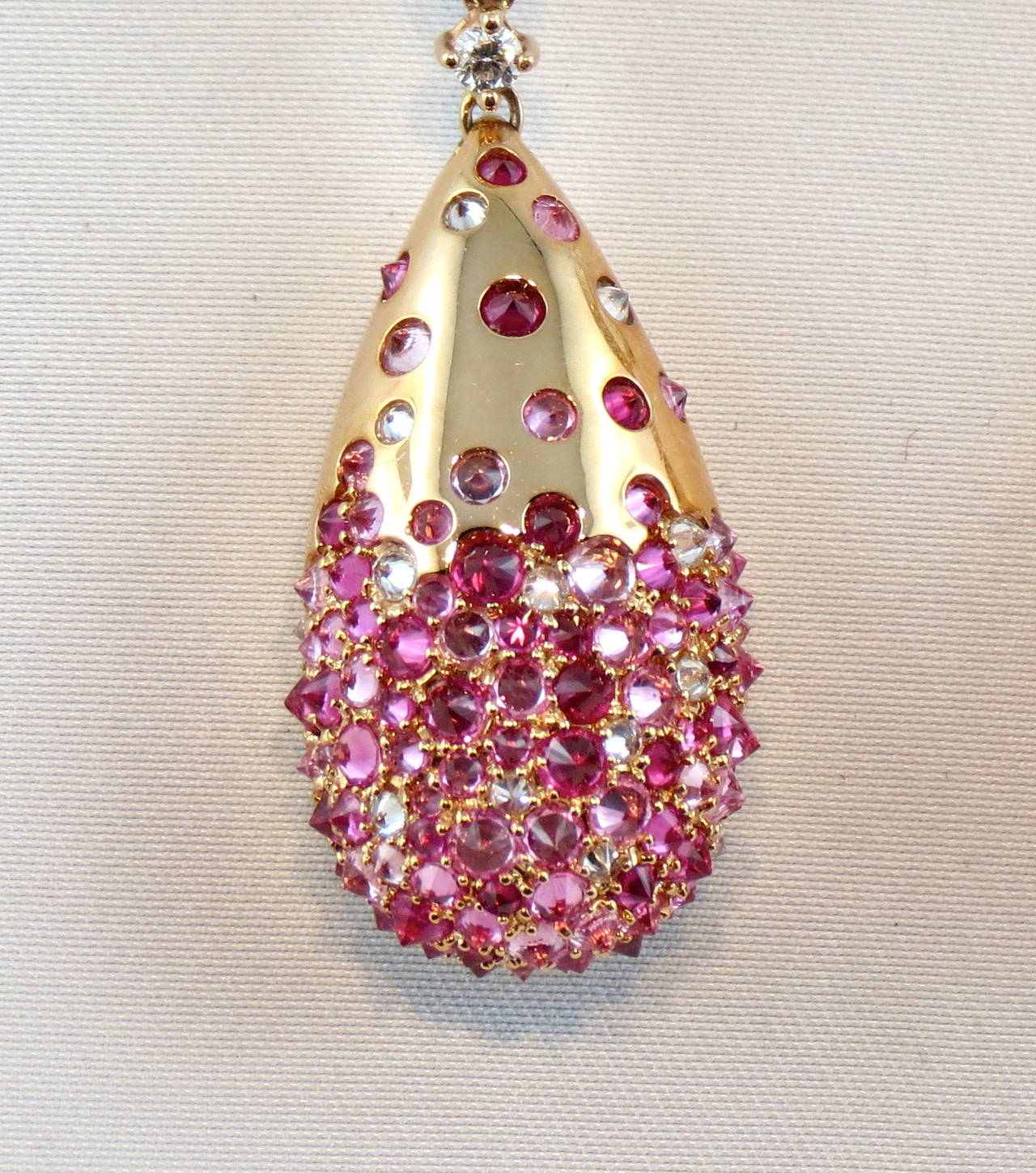 Jona design collection, hand crafted in Italy, 18 Karat rose gold, pair of drop ear clip pendants( a hinged stud can be lifted if required or lowered) . The earrings feature 5.11 carats of pink sapphires, 1.20 carats of ruby's and 1.81 carats of