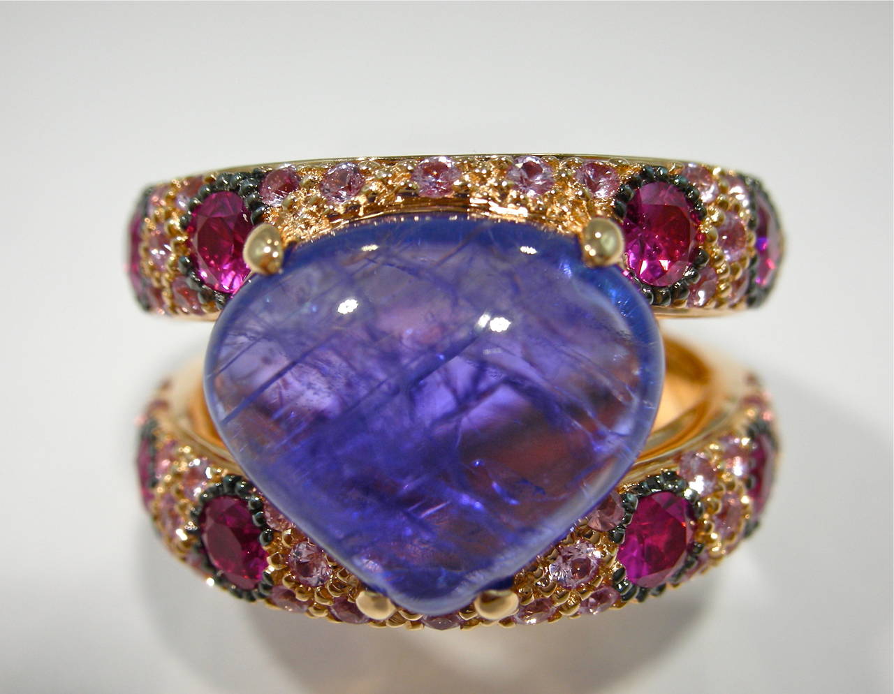 Jona design collection, a cabochon Tanzanite weighing 5.05 carats mounted on  a 18k rose gold ring with twelve rubies set inside a pink sapphire pavé. Designed and hand crafted in Italy (size 6.5 can be sized)
