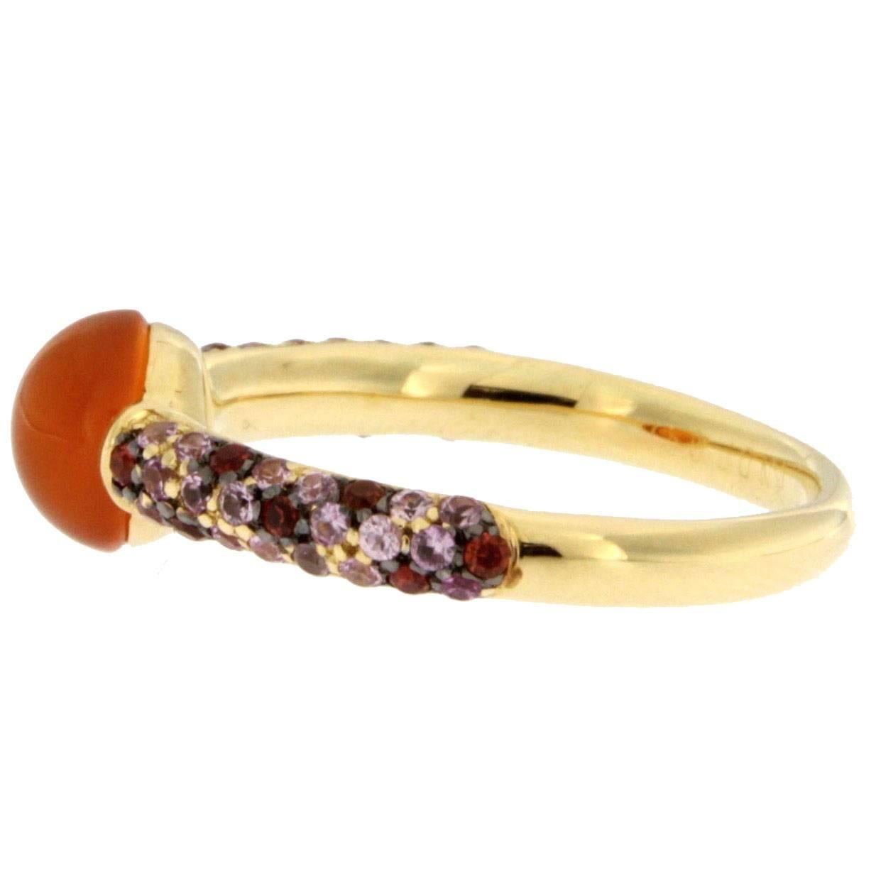 Jona design collection, hand crafted in Italy, 18 karat yellow gold ring centering a cabochon carnelian weighting 1 carat. Shoulders are set with 0.48 carats of orange sapphires and 1.02 carats of pink sapphires. 
Ring size US. 6.8, can be sized to