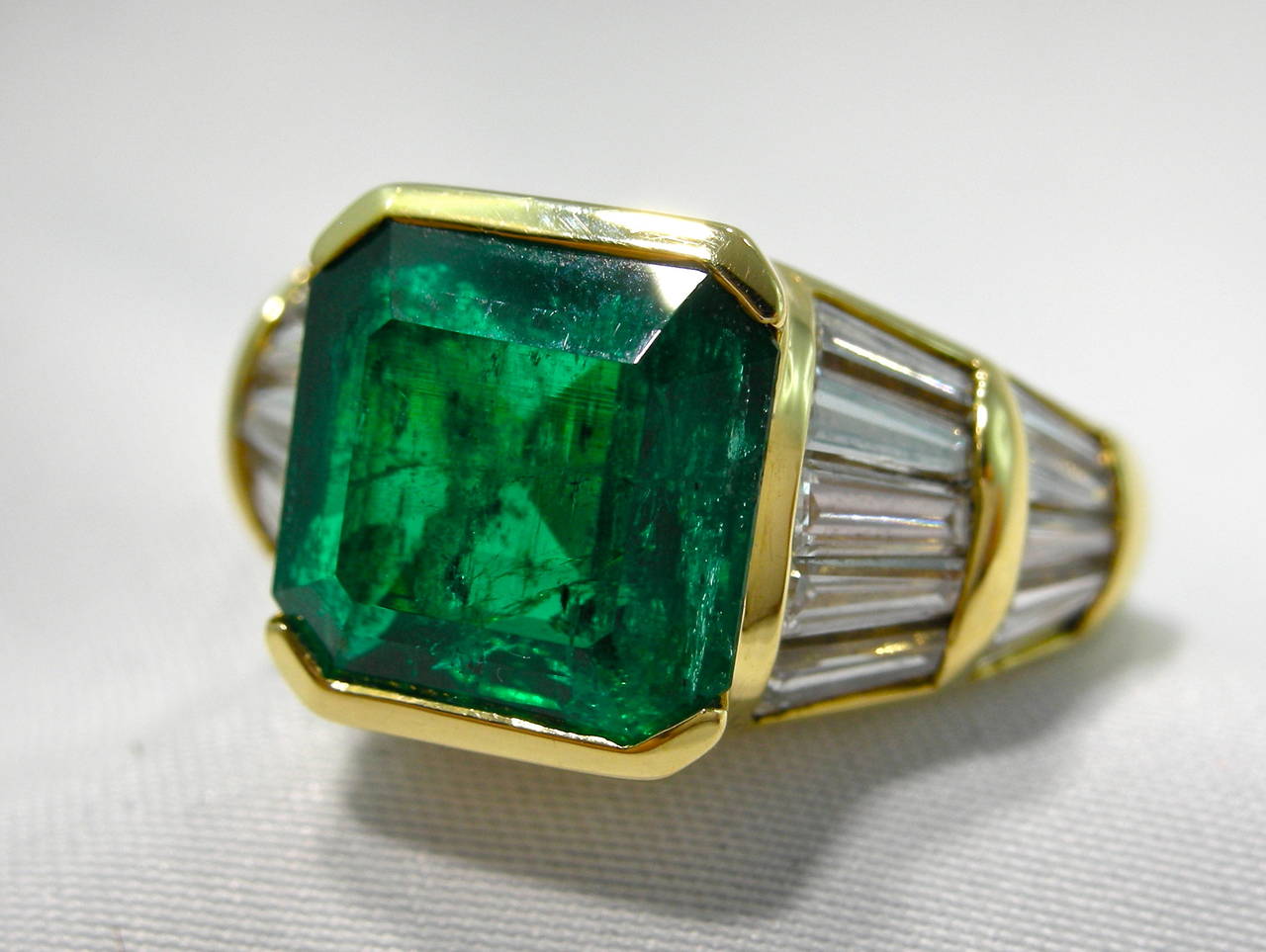 Jona design collection, 18 Karat yellow gold emerald and diamond ring. The emerald weights 3.70 carats of Colombian origin. The 20 tapered baguettes diamonds weight 2.30 carats.

US size 7.5 ; can be sized.

All of our jewelry is new and has